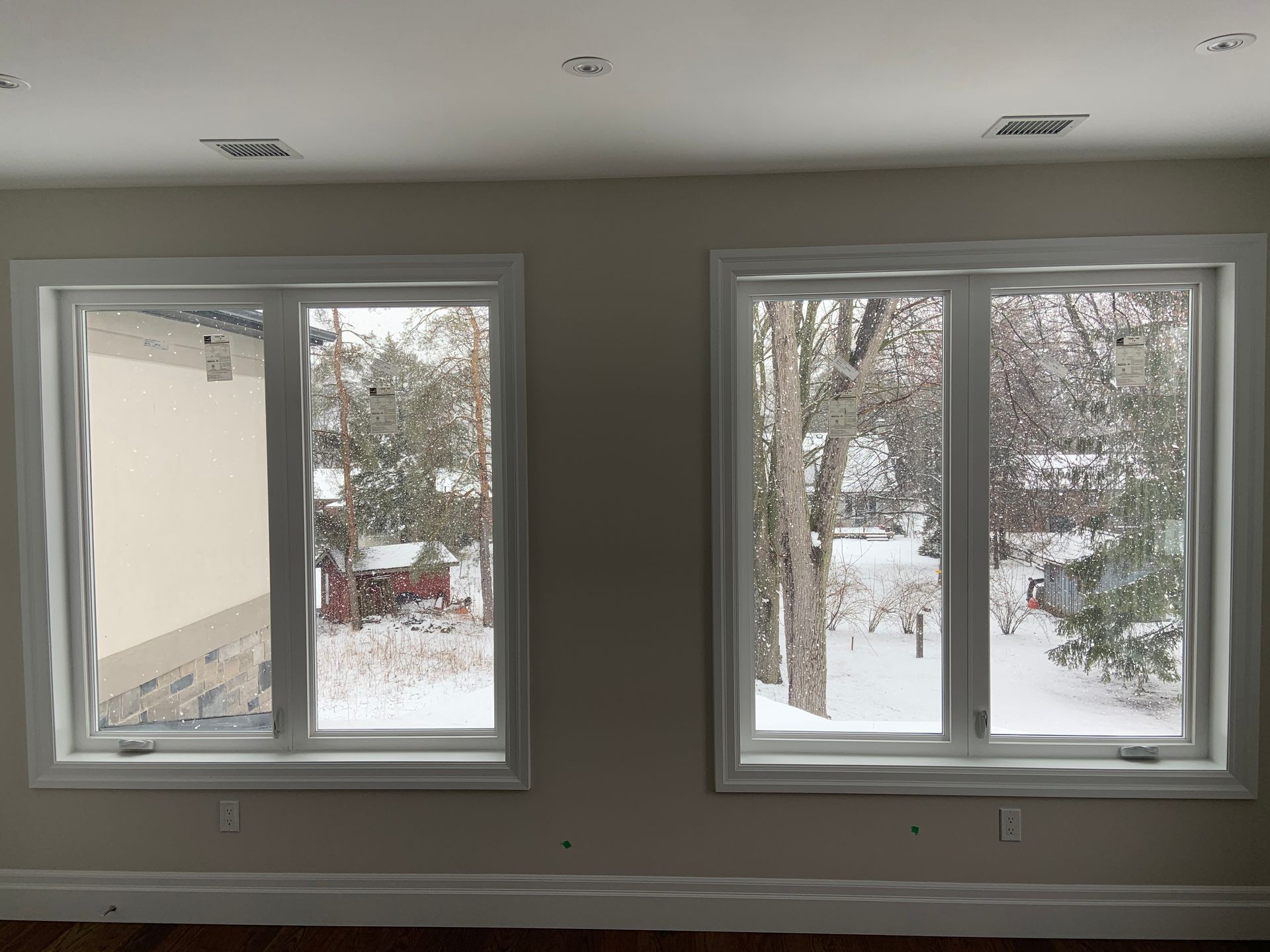 A room with two windows looking out to a snowy yard