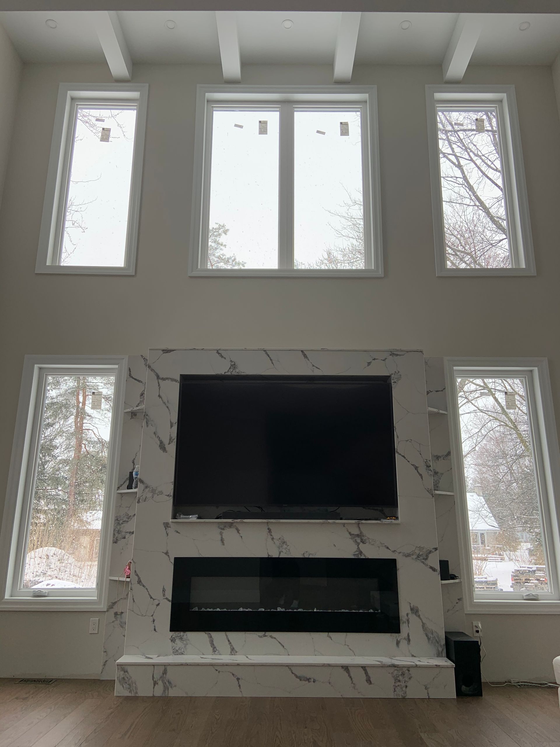 A living room with a fireplace and a flat screen tv on the wall.
