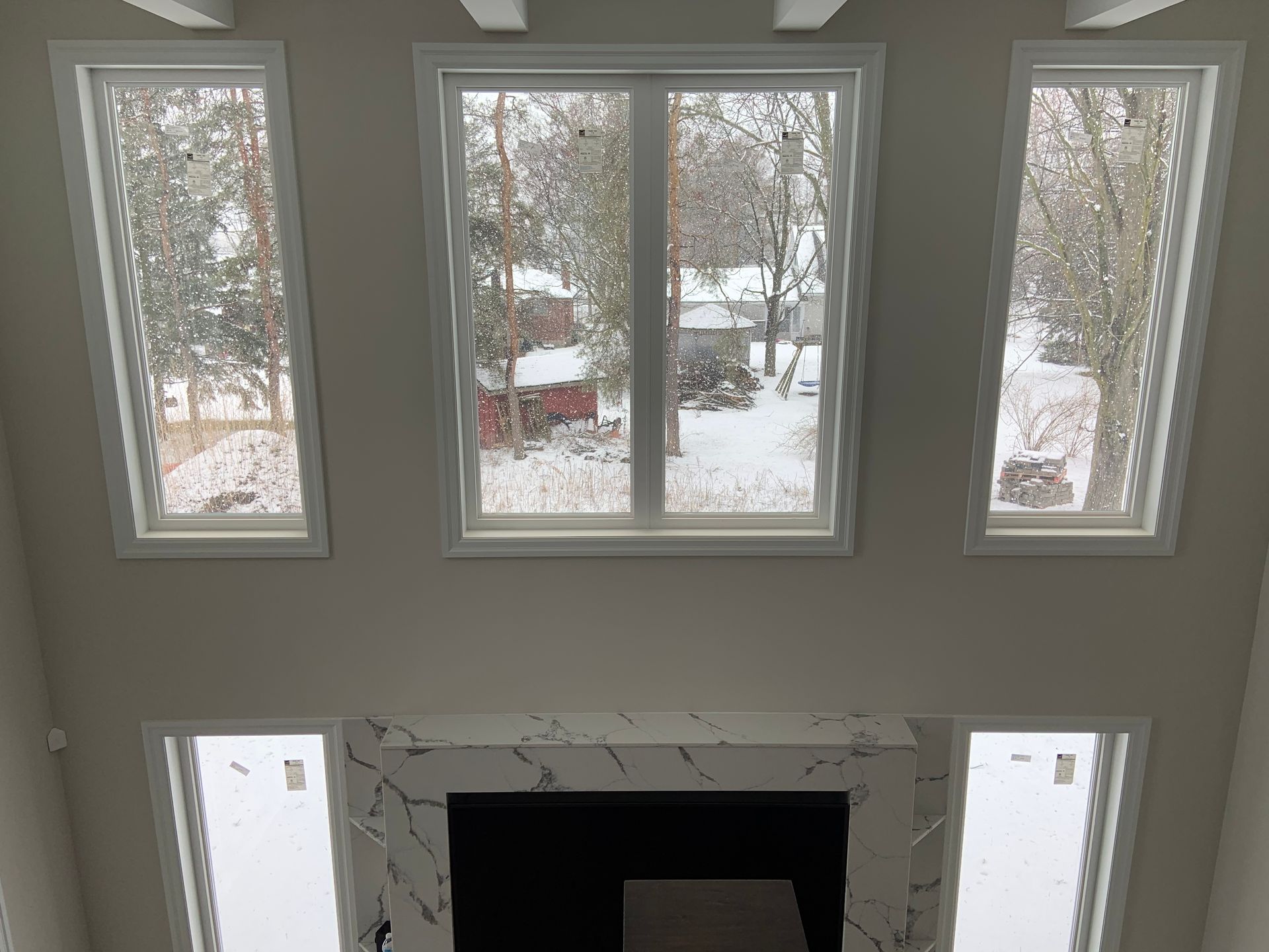 A living room with a fireplace and a lot of windows.