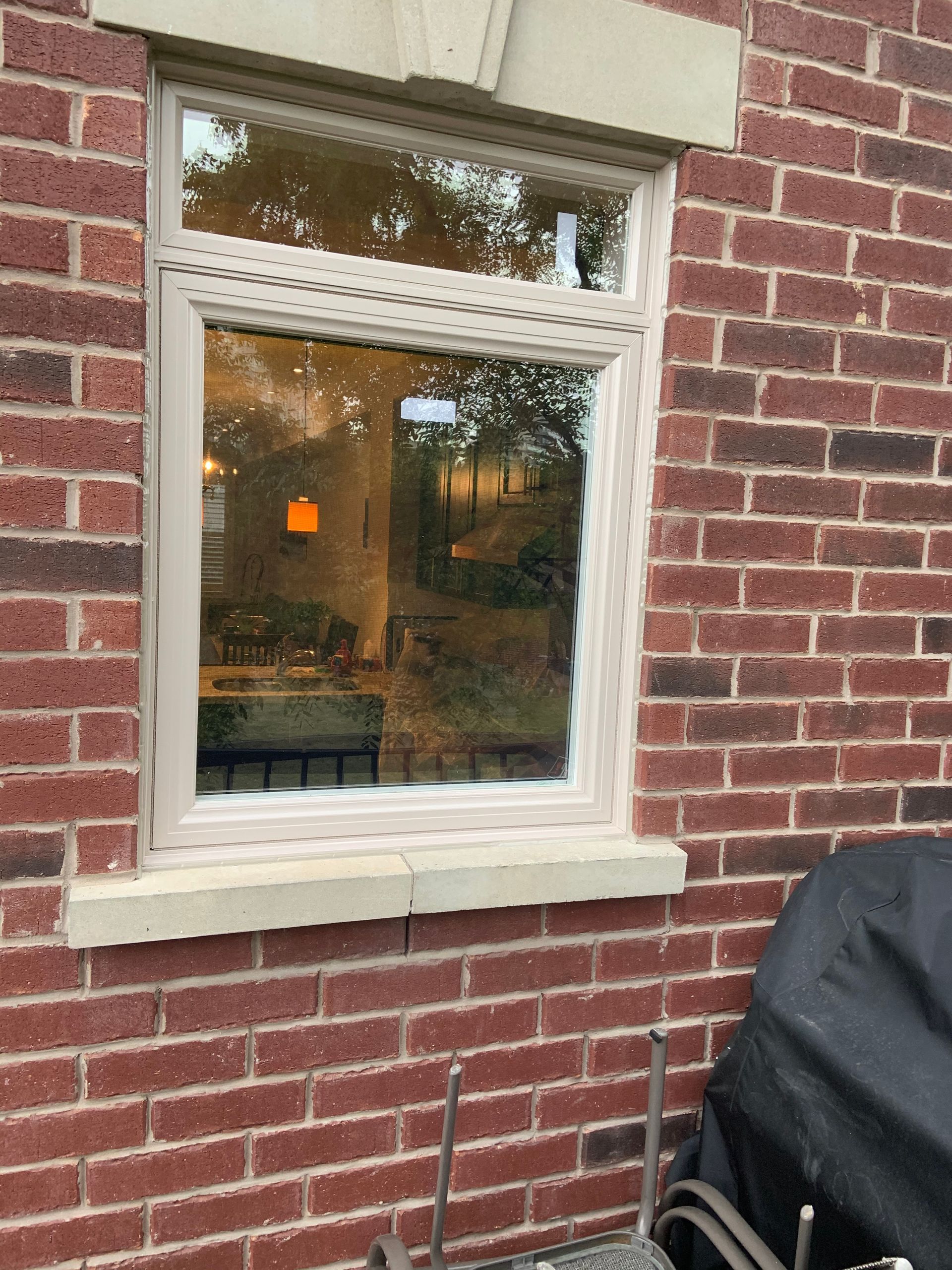 A brick building with a window and a grill