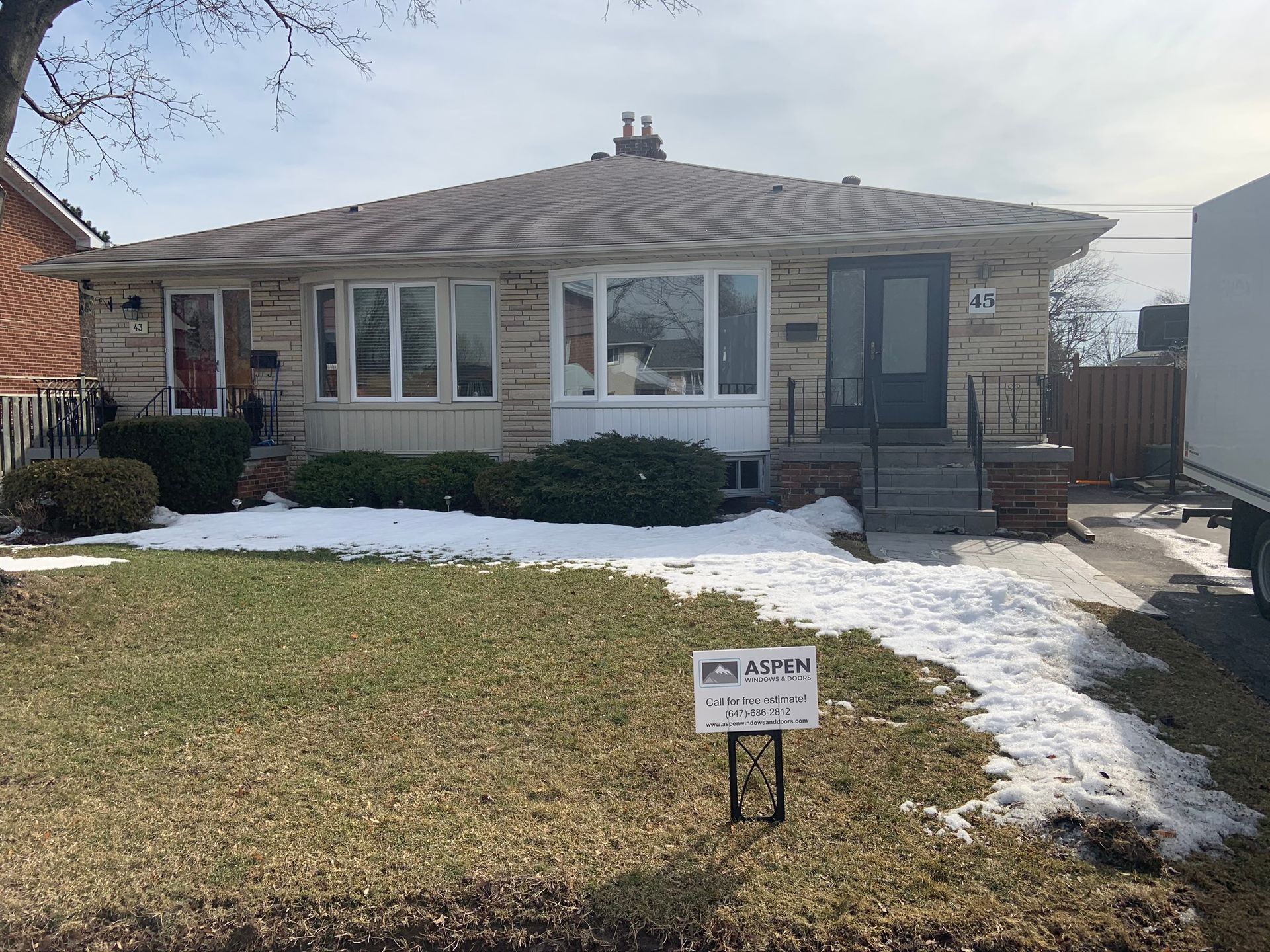 A house with a for sale sign in front of it.