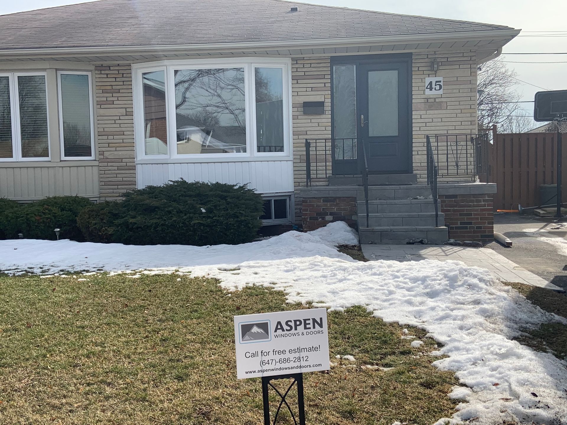 A house with a for sale sign in front of it.