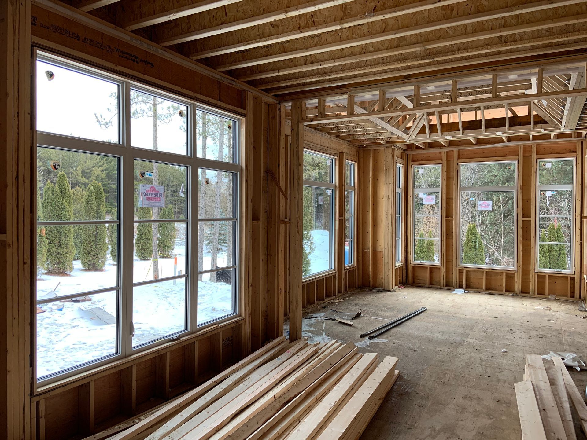 A room in a house under construction with a lot of windows.