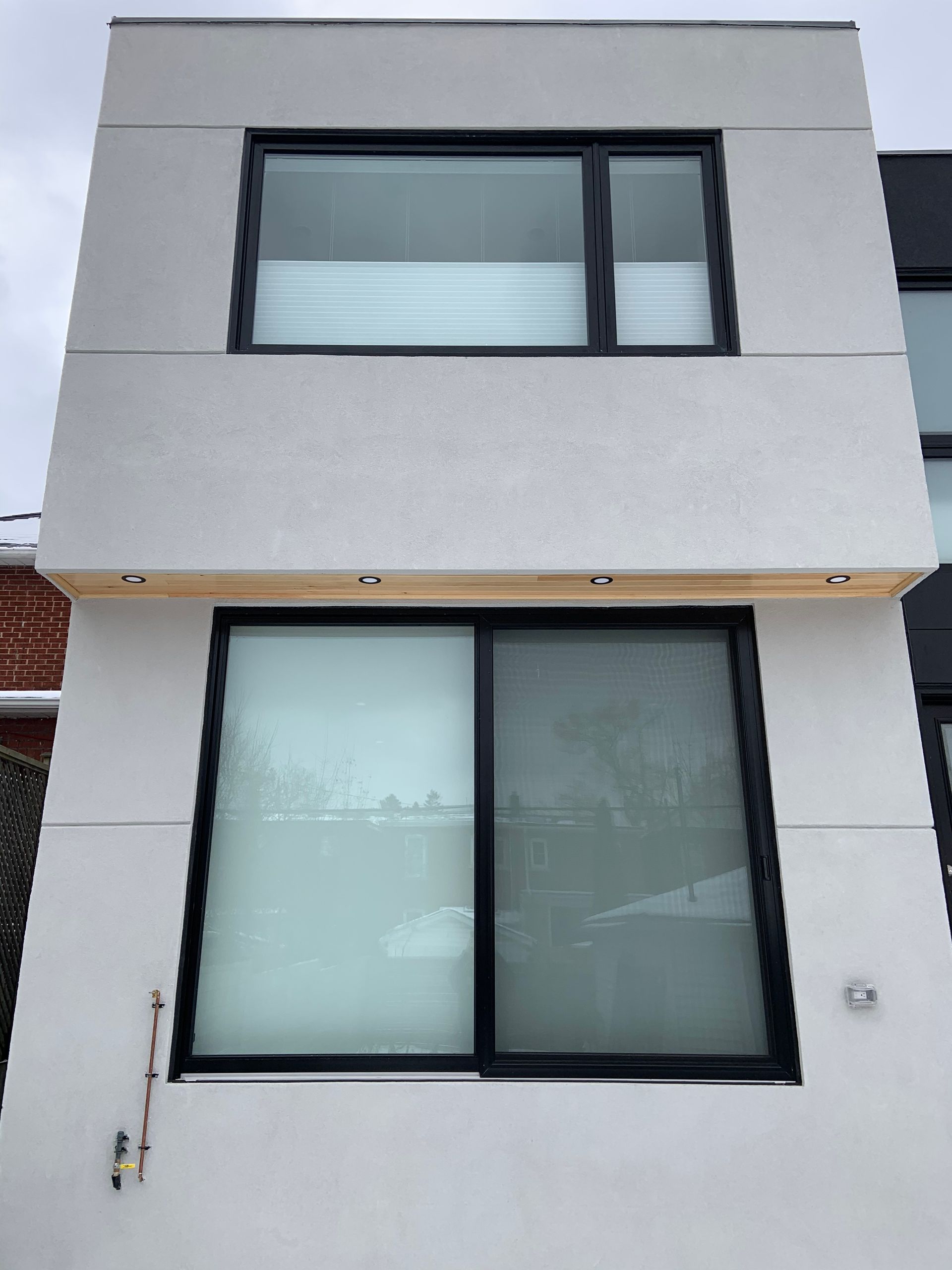 A white building with black windows and a balcony.