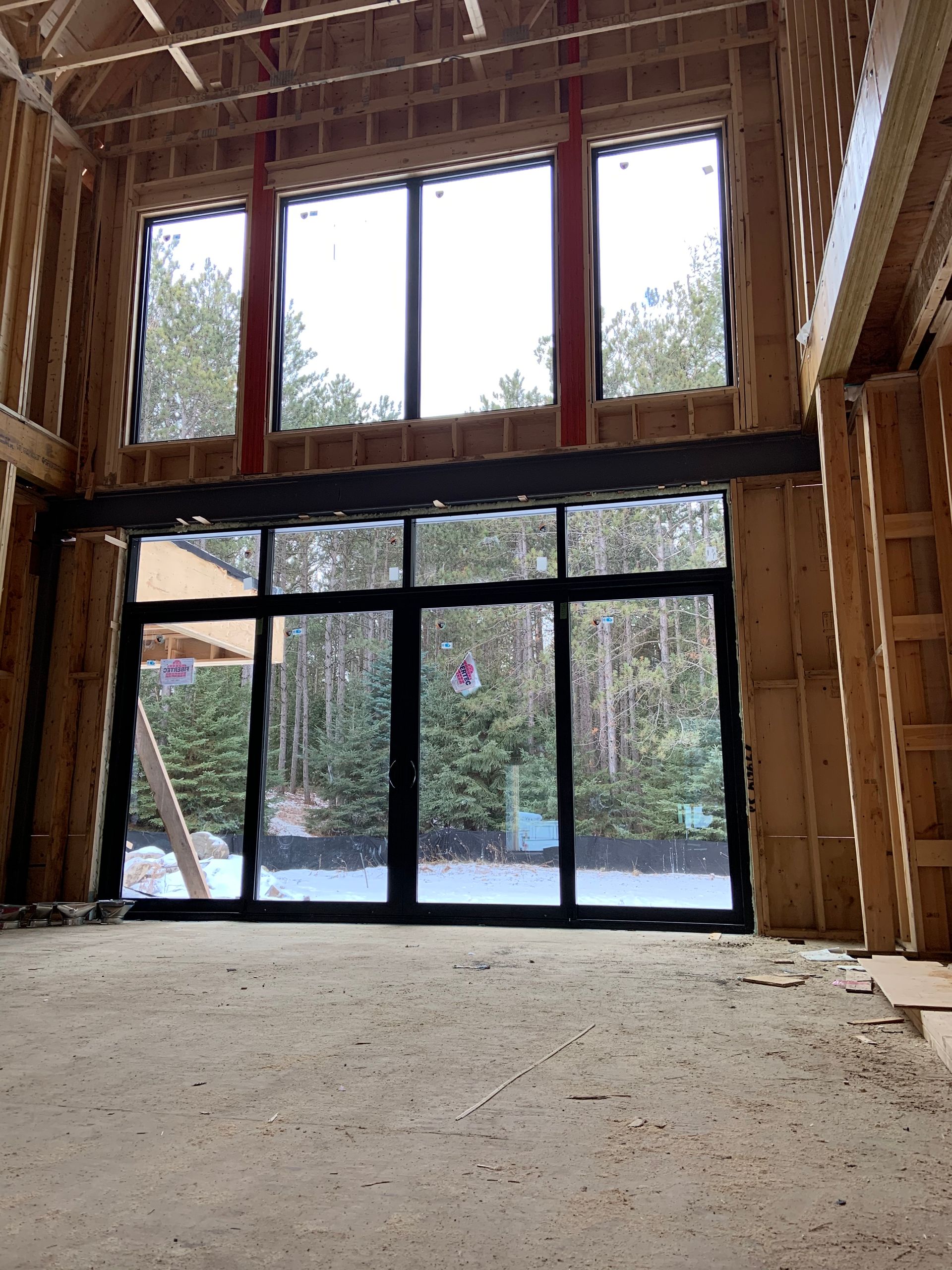 An empty room with a lot of windows and trees in the background.