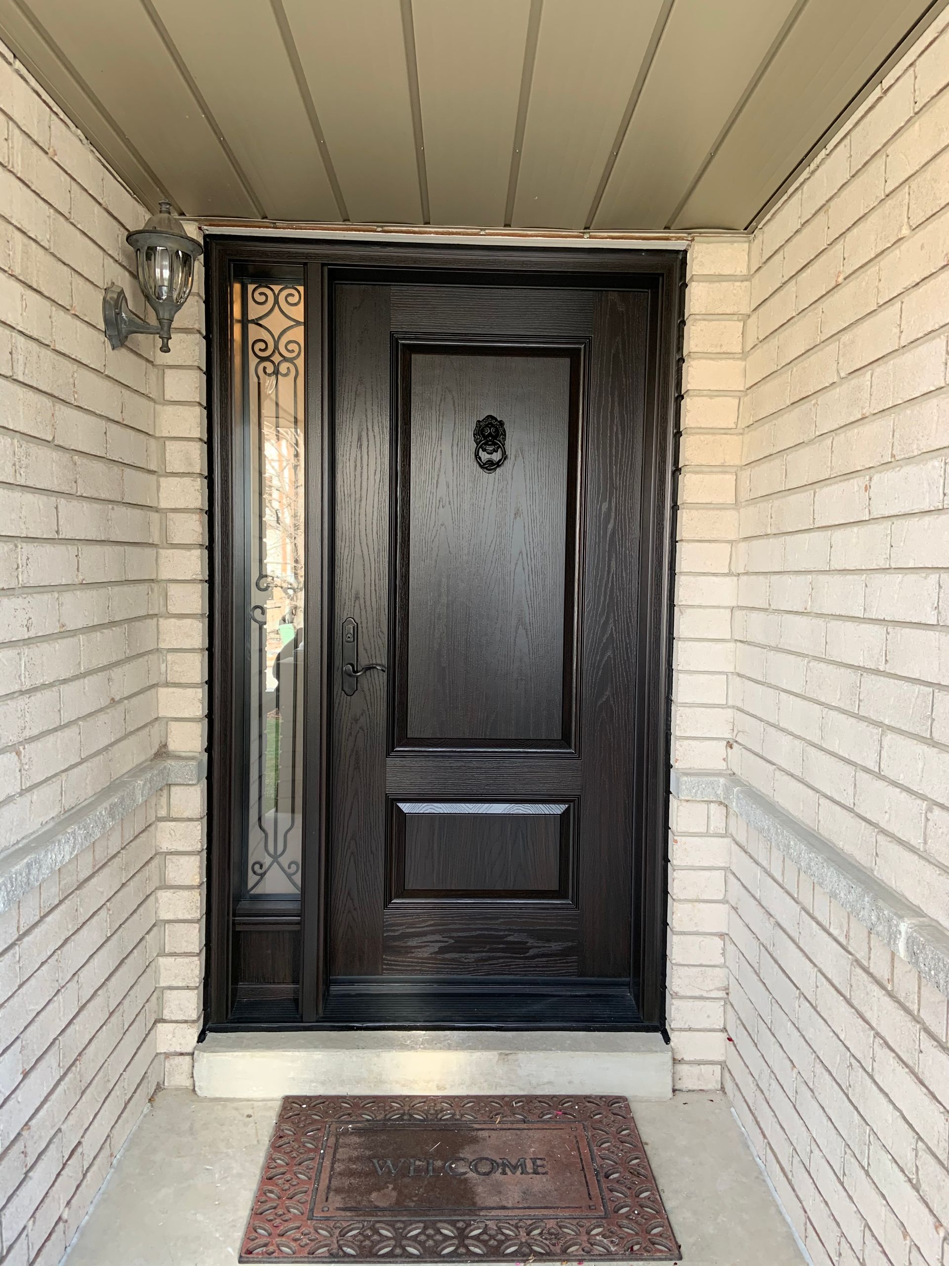 A black front door with a rug in front of it