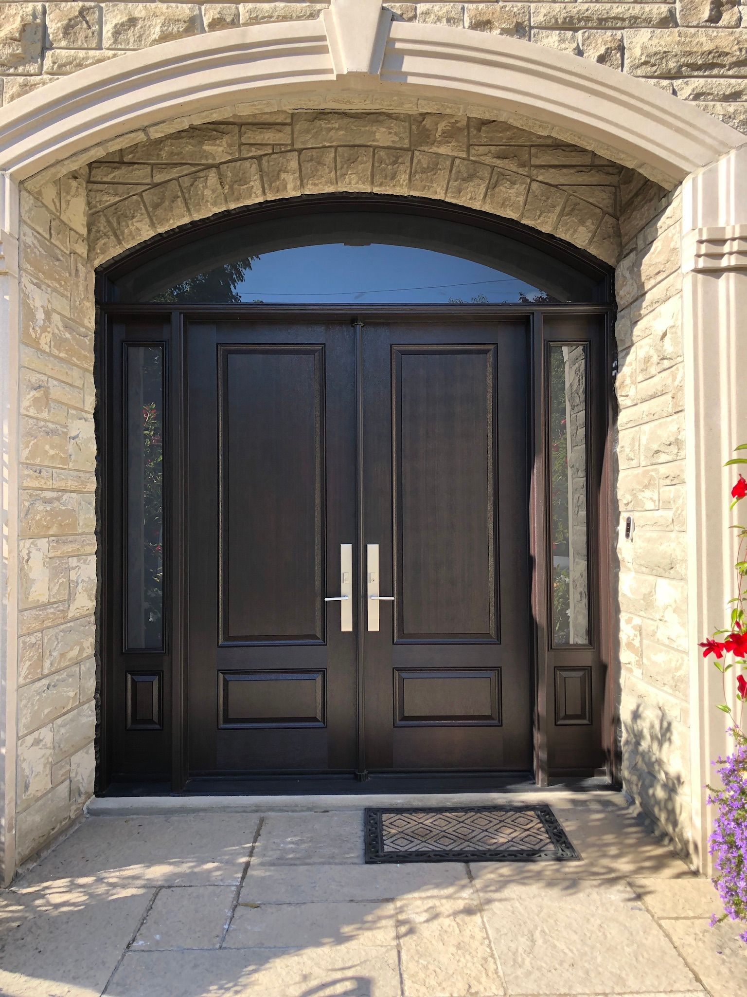 The front door of a brick building with a black double door.