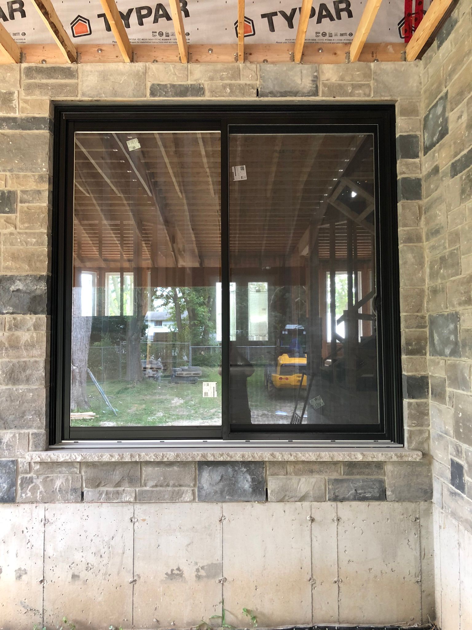 A window in a brick building with a sliding glass door