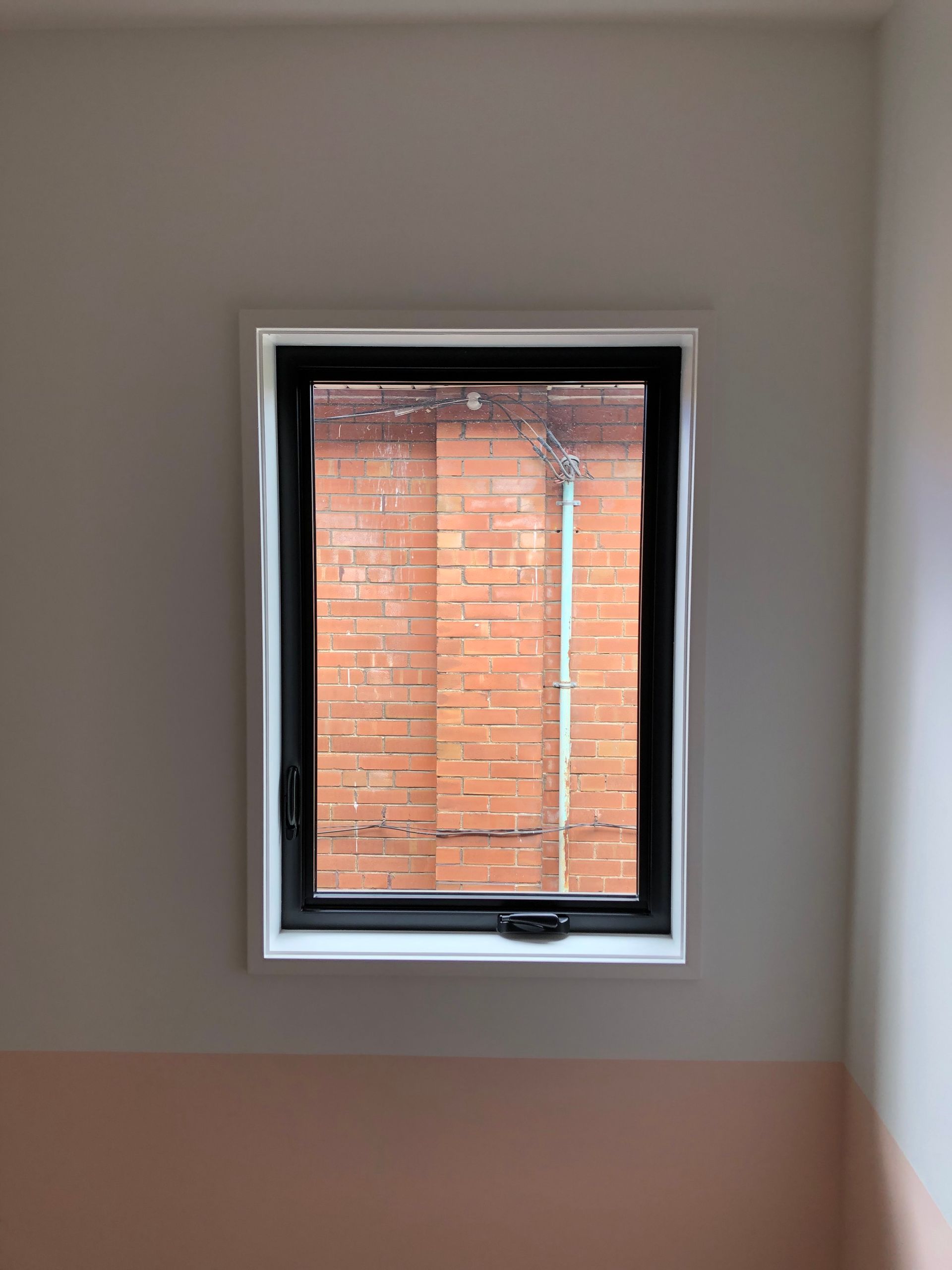 A window in a room with a brick wall in the background.