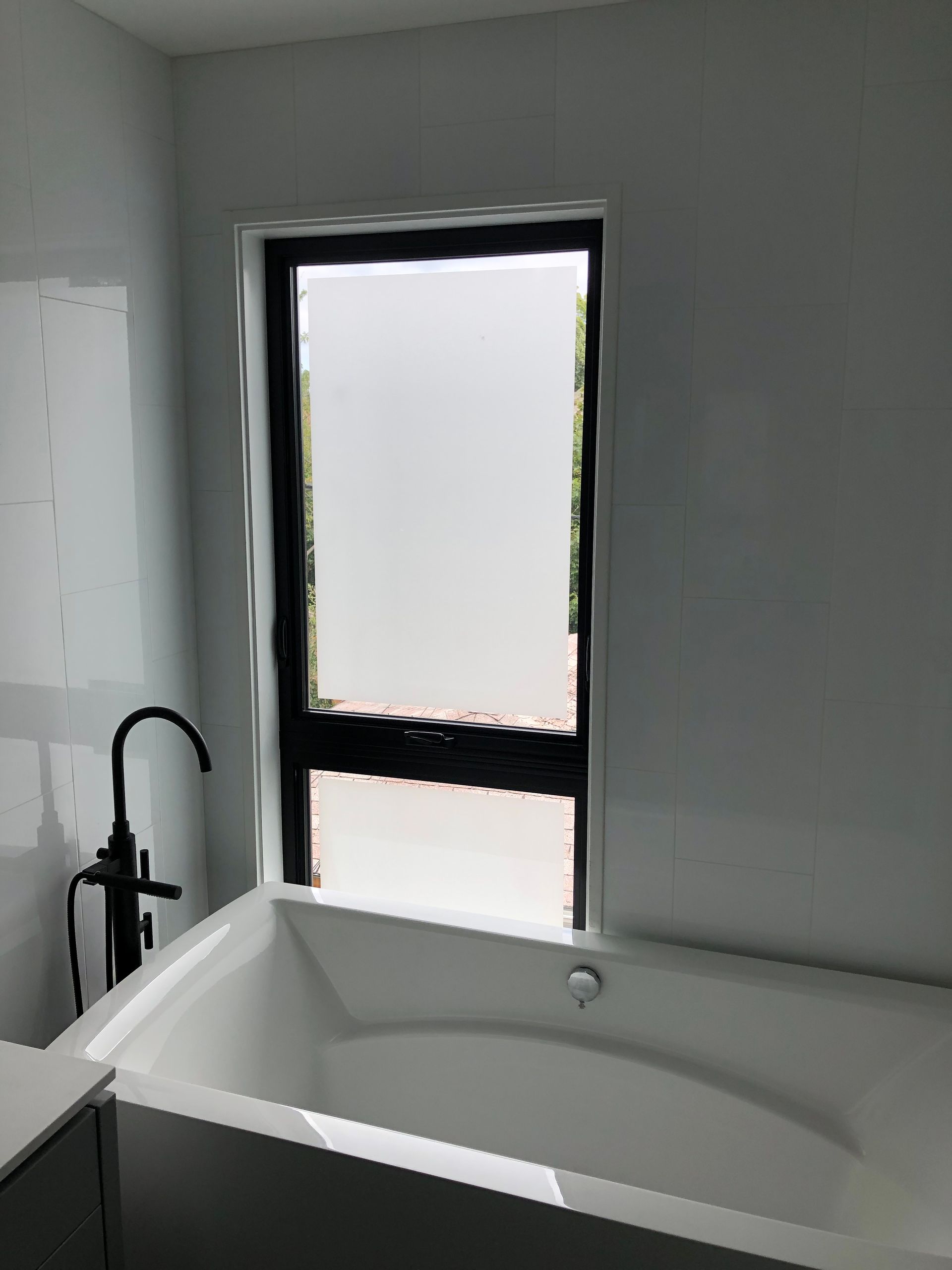 A bathtub in a bathroom next to a window.