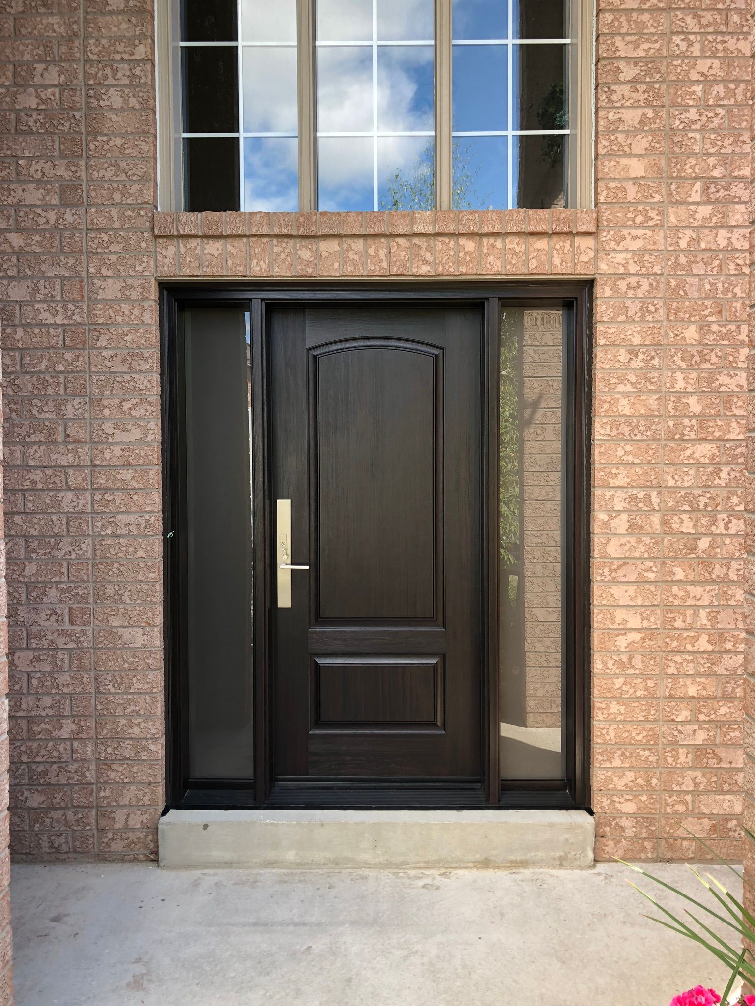 A brick building with a black door and a window