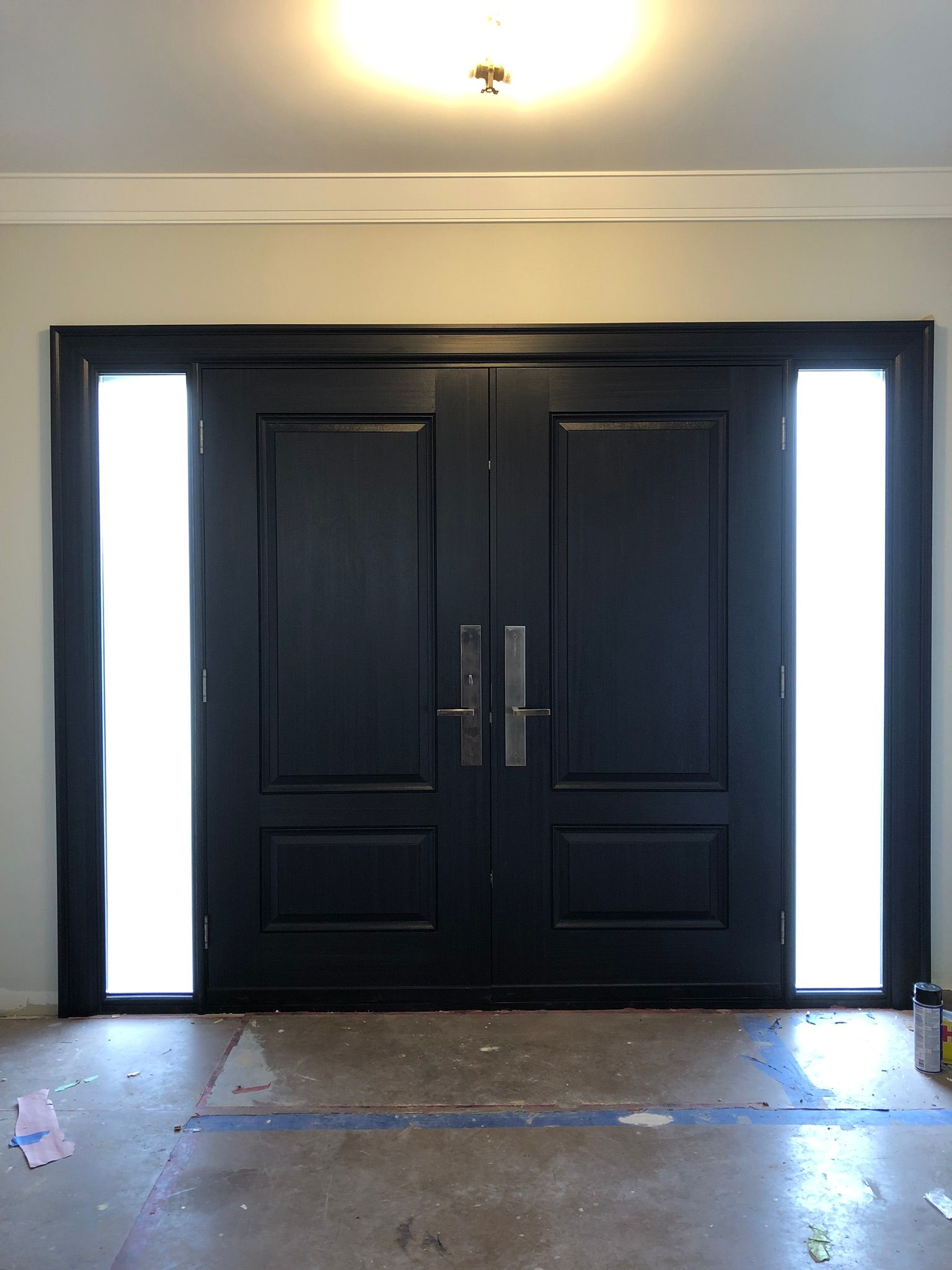 A black door with two windows in a room