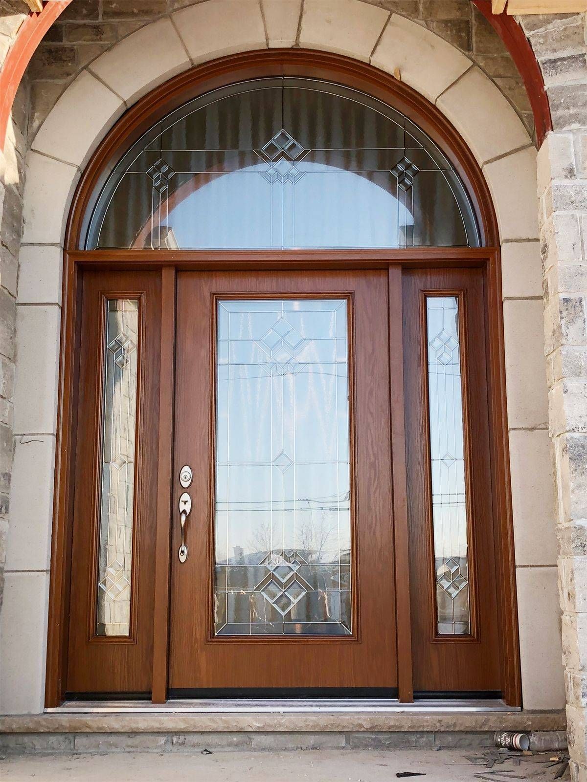 A large wooden door with a stained glass window