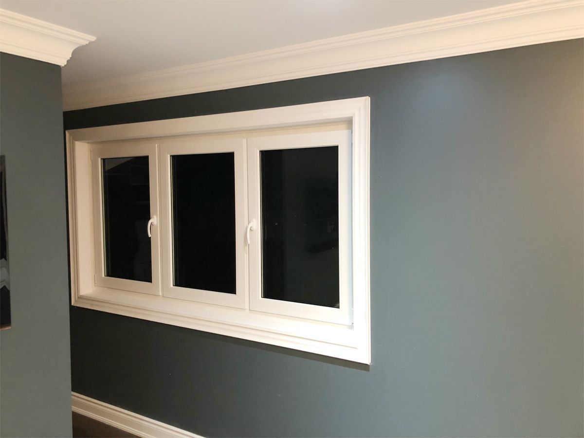 A window in a room with blue walls and white trim