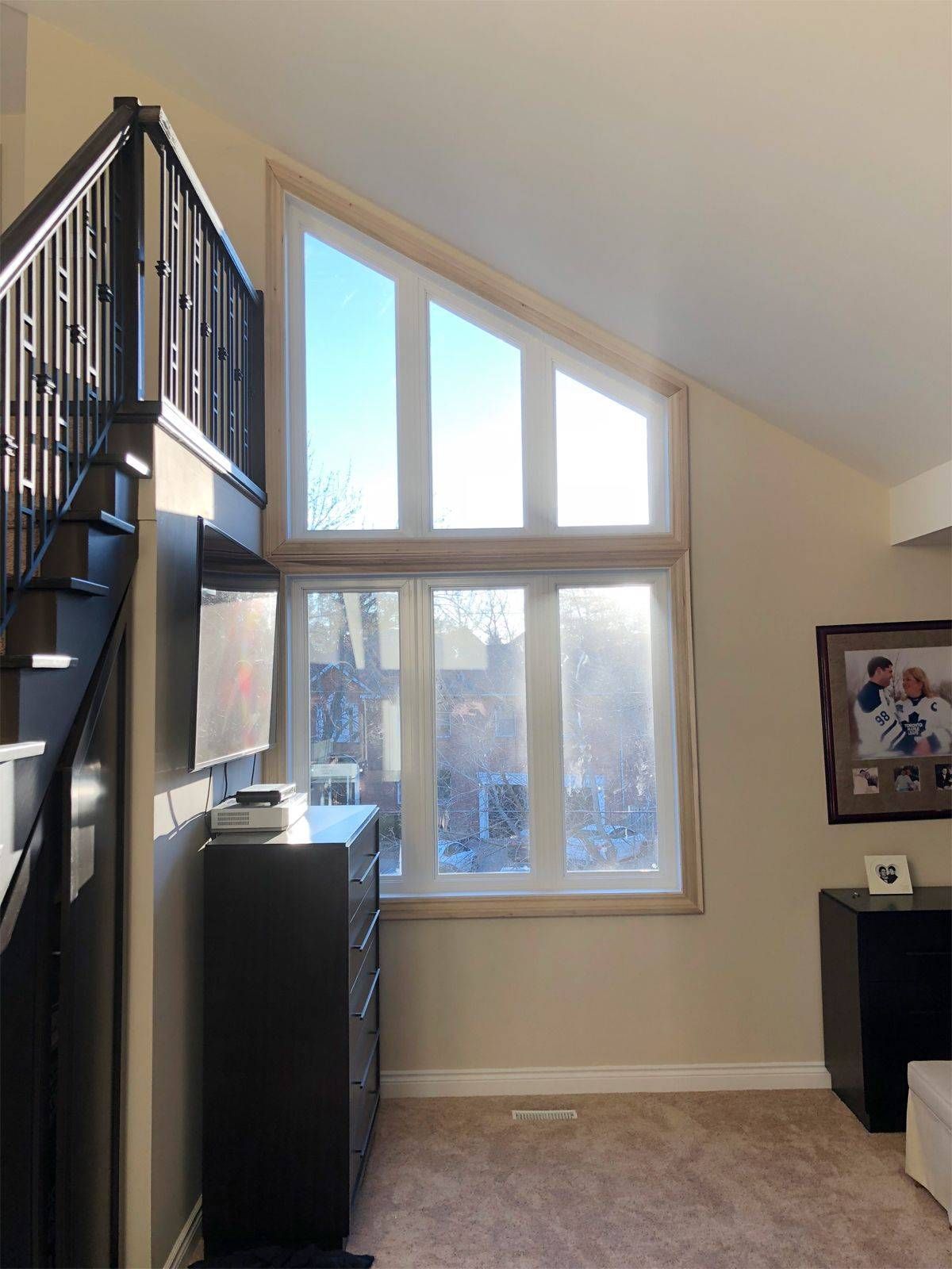 A living room with a staircase and a large window