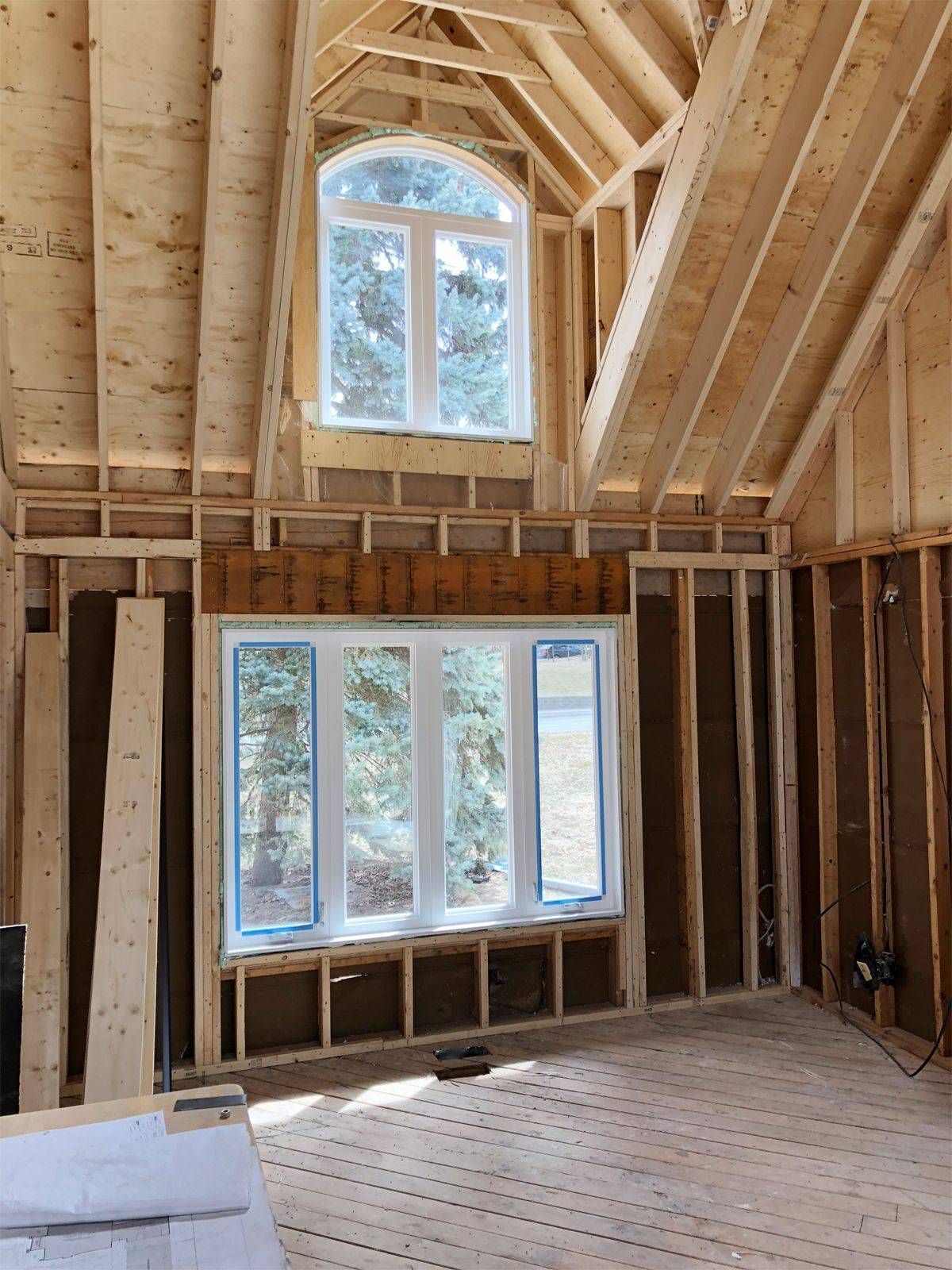 A room in a house under construction with a large window.
