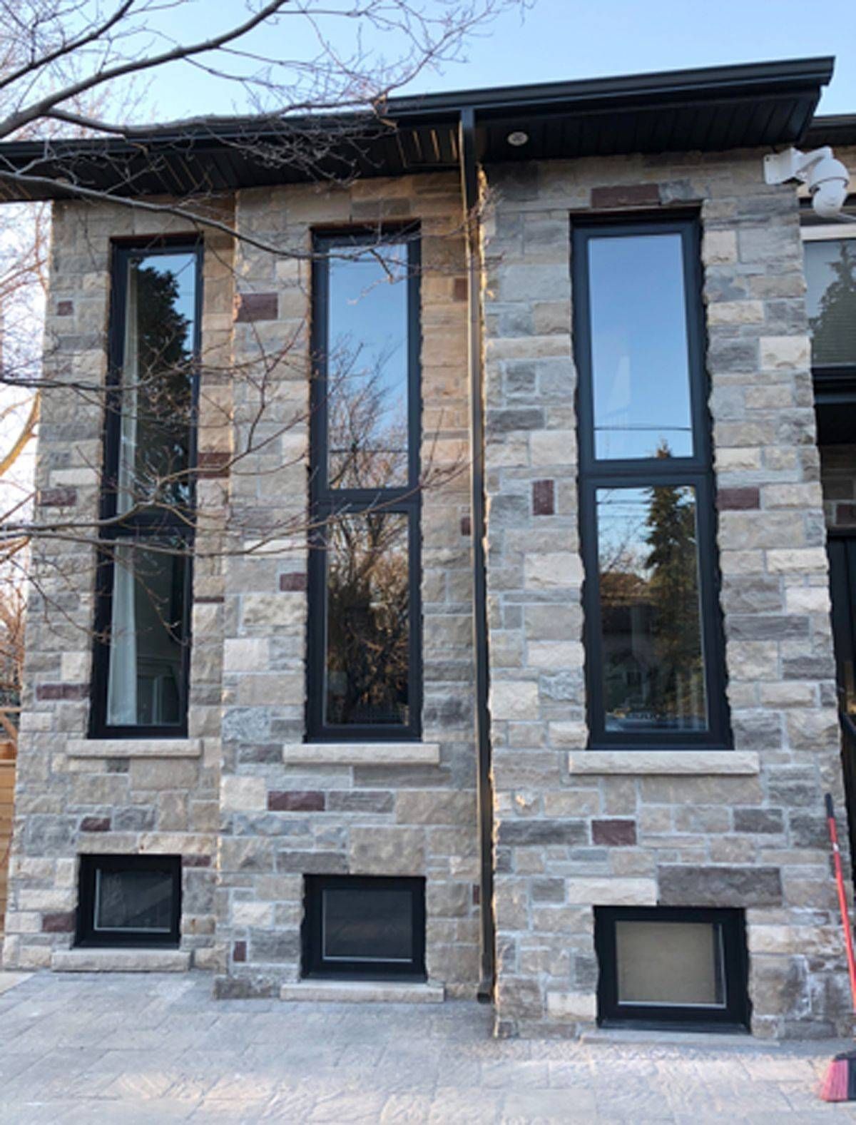 A house with a stone facade and black windows