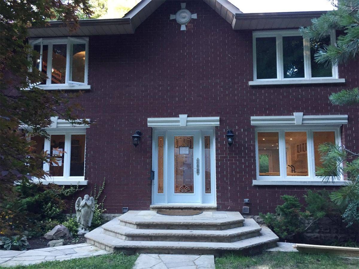 A brick house with white windows and a white door