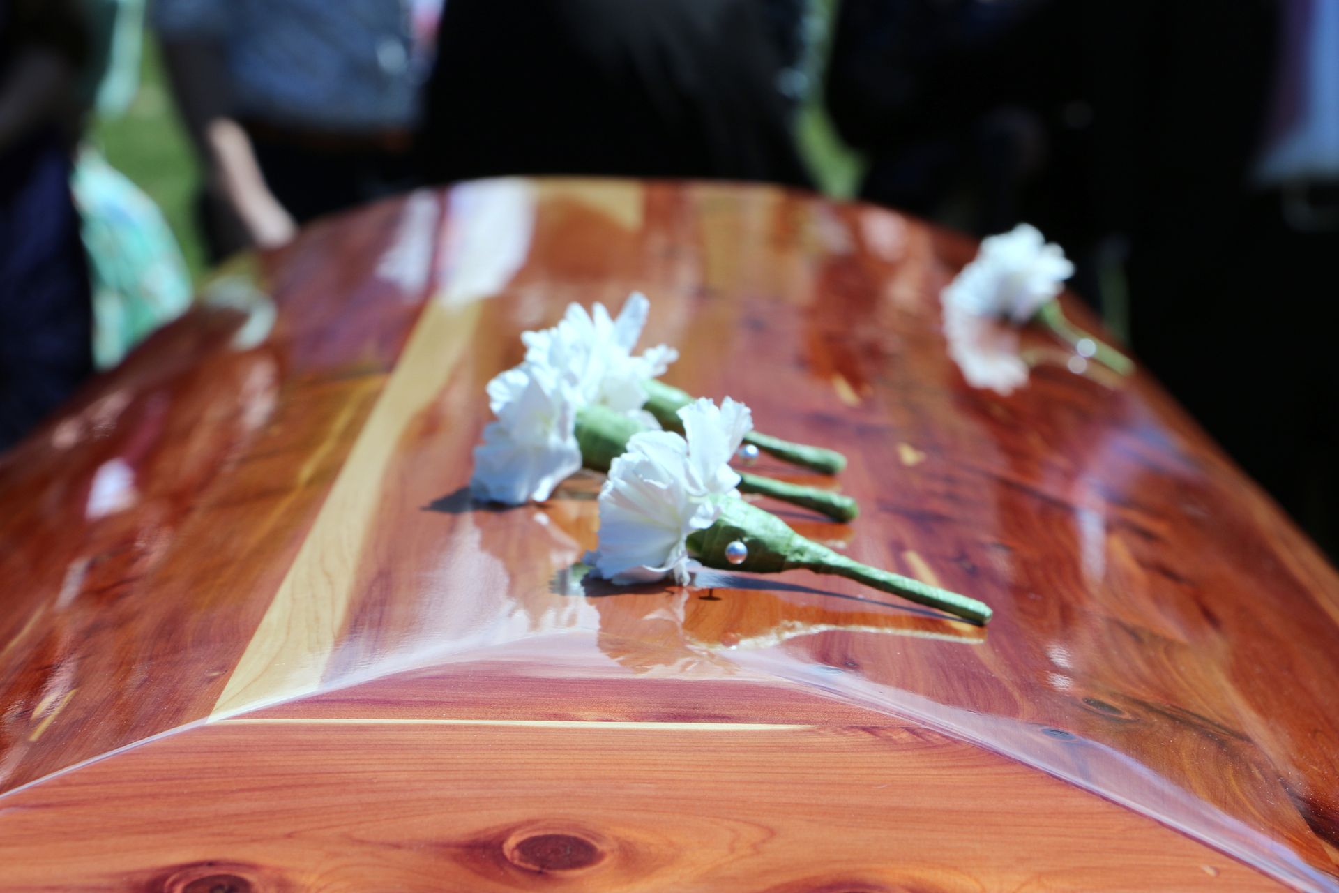 Wooden casket with white flowers on top.