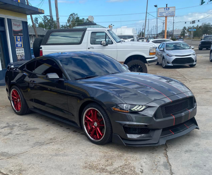 A Goodyear auto repair shop with a white building, blue trim, a service bay entrance, and a bench on the sidewalk.