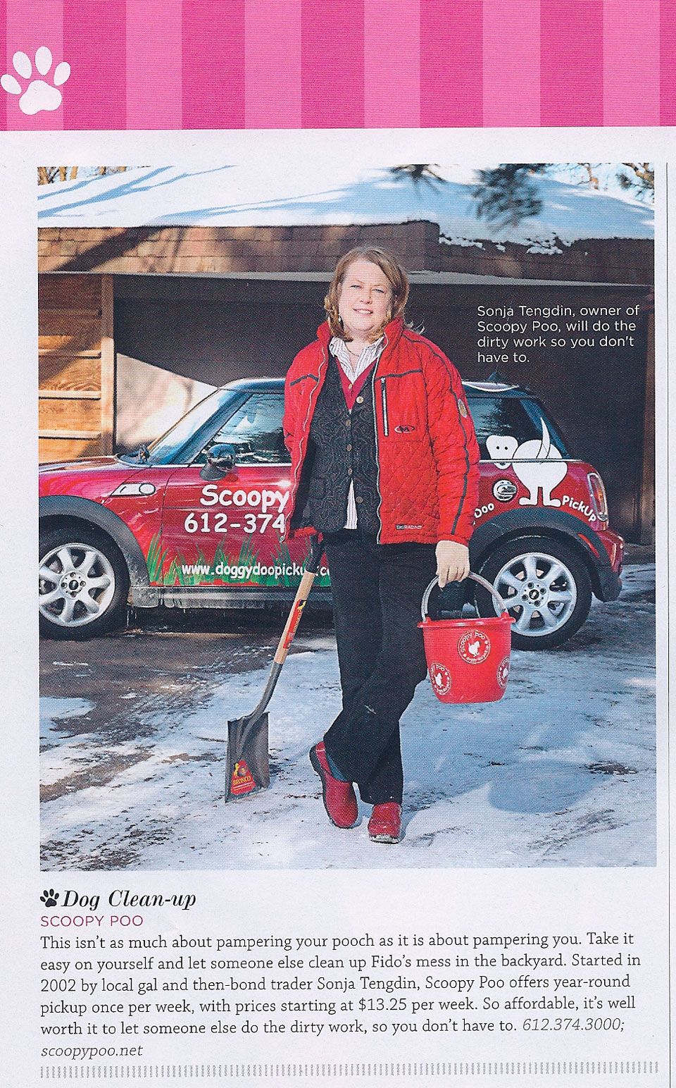 A woman is shoveling snow in front of a red mini cooper.