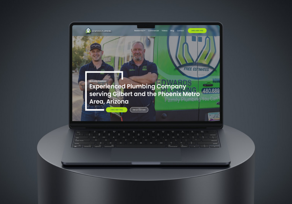 Hand holding a phone displaying the Google Ads logo against a blurred background of a computer screen with charts.