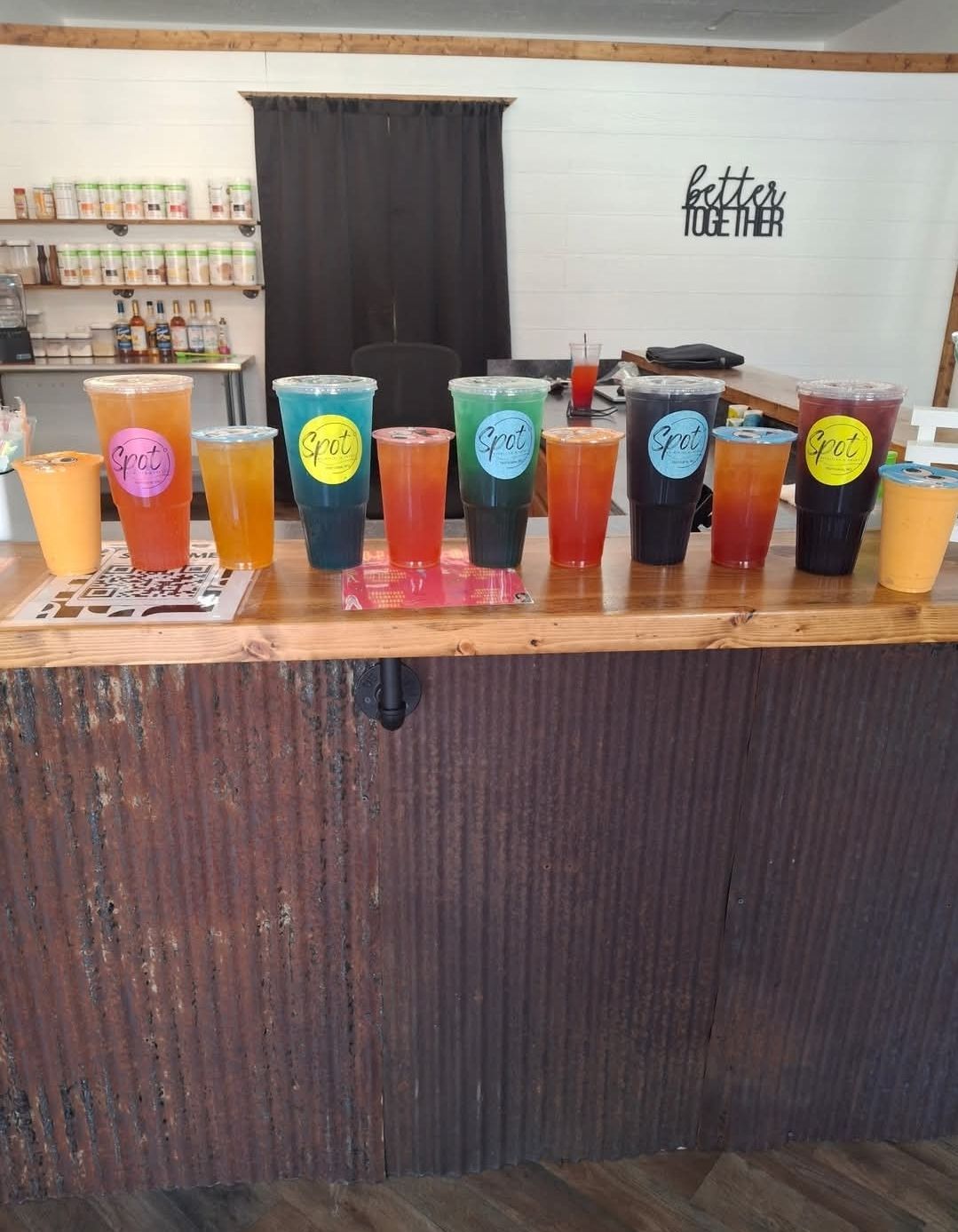 A person is holding a cup of iced tea with a straw in their hand.