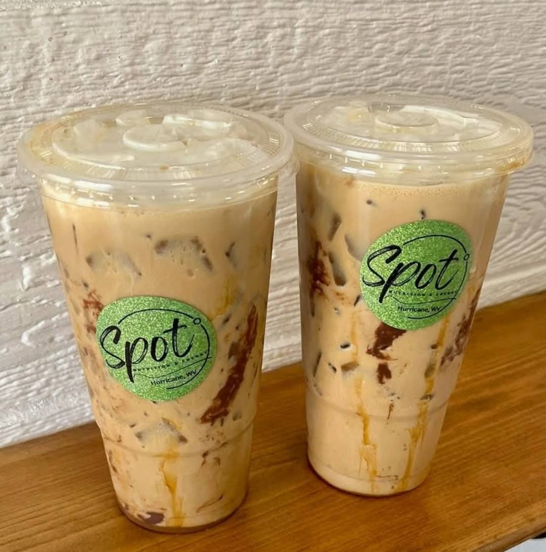 A cup of coffee is being poured into a cup on a plate.