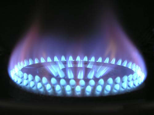 A close up of a gas burner with blue flames