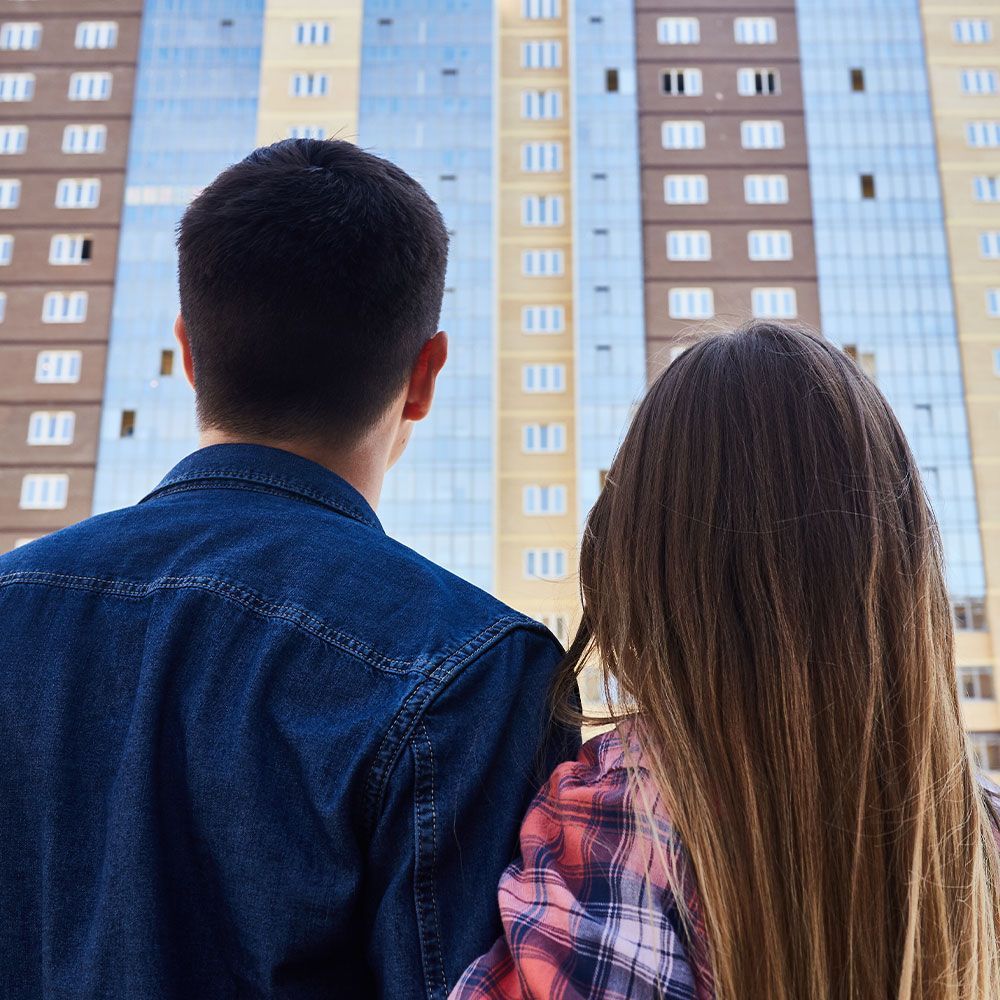 A man and a woman are looking at a tall building