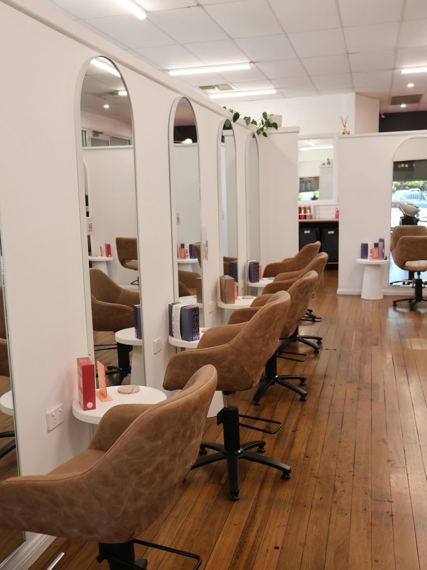 Modern Hair Salon with Brown Styling Chairs, Tall Mirrors, and Wooden Floors — Pose Hair Design in Orange, NSW