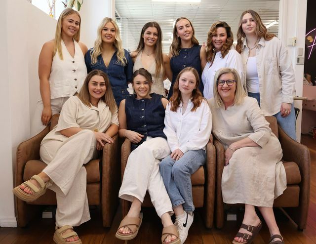 Group of Nine People Posing Together in A Bright Room — Pose Hair Design in Orange, NSW