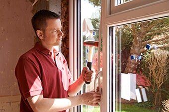 Construction Worker Installing New Windows In House — Home Repairs in Hampton, VA