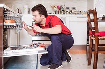 Worker Repairing the Dishwasher in the Kitchen — Home Repairs in Hampton, VA