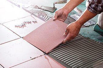 Worker Installing Tiles — Home Improvement in Hampton, VA