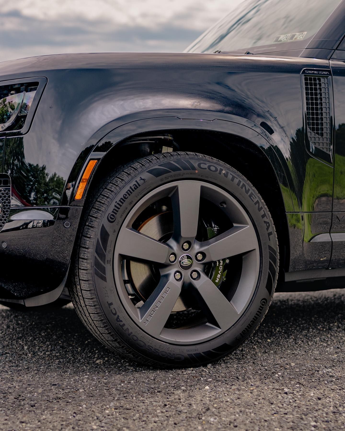 A close up of the hood of a red corvette.