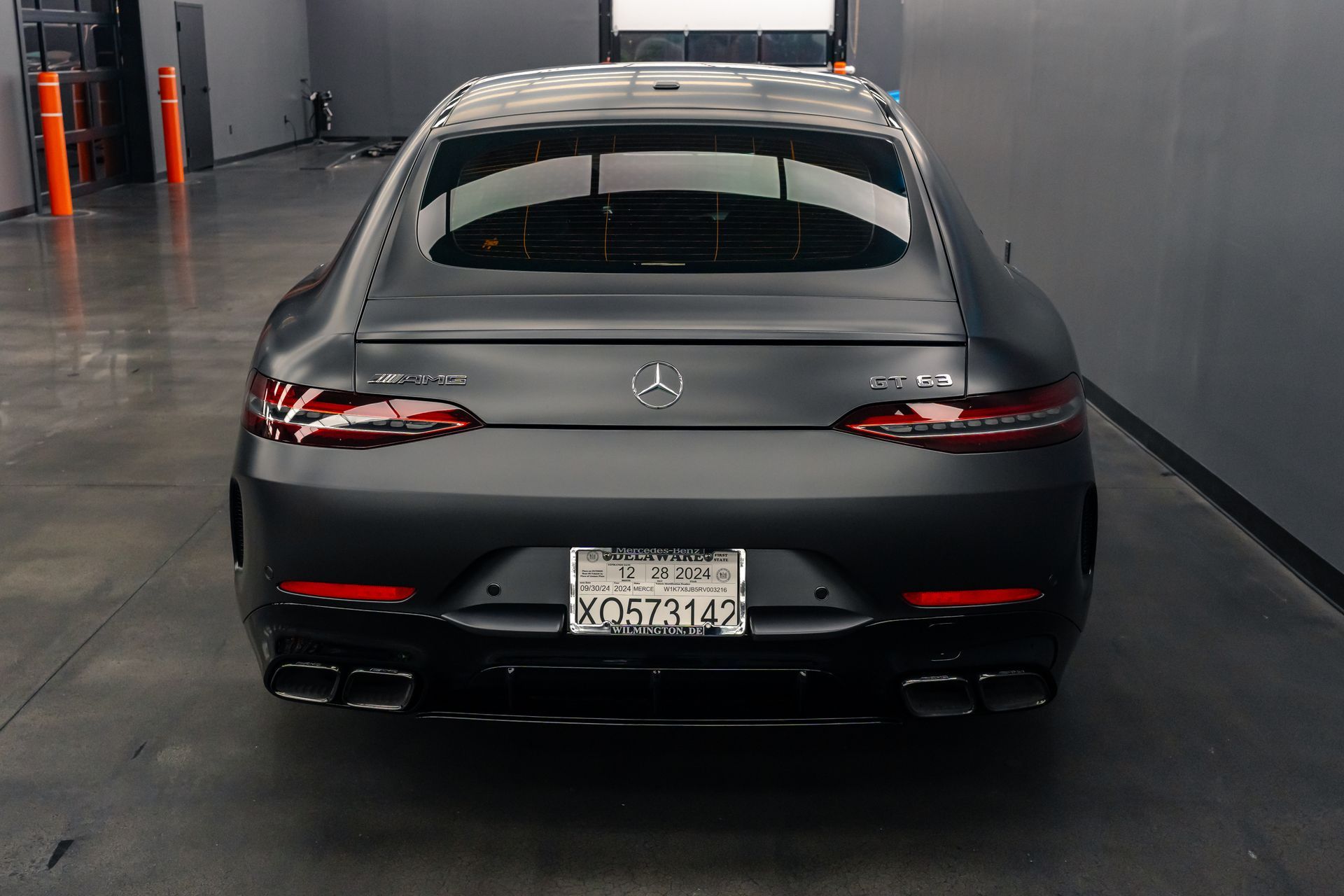 A black mercedes benz is parked in a garage.