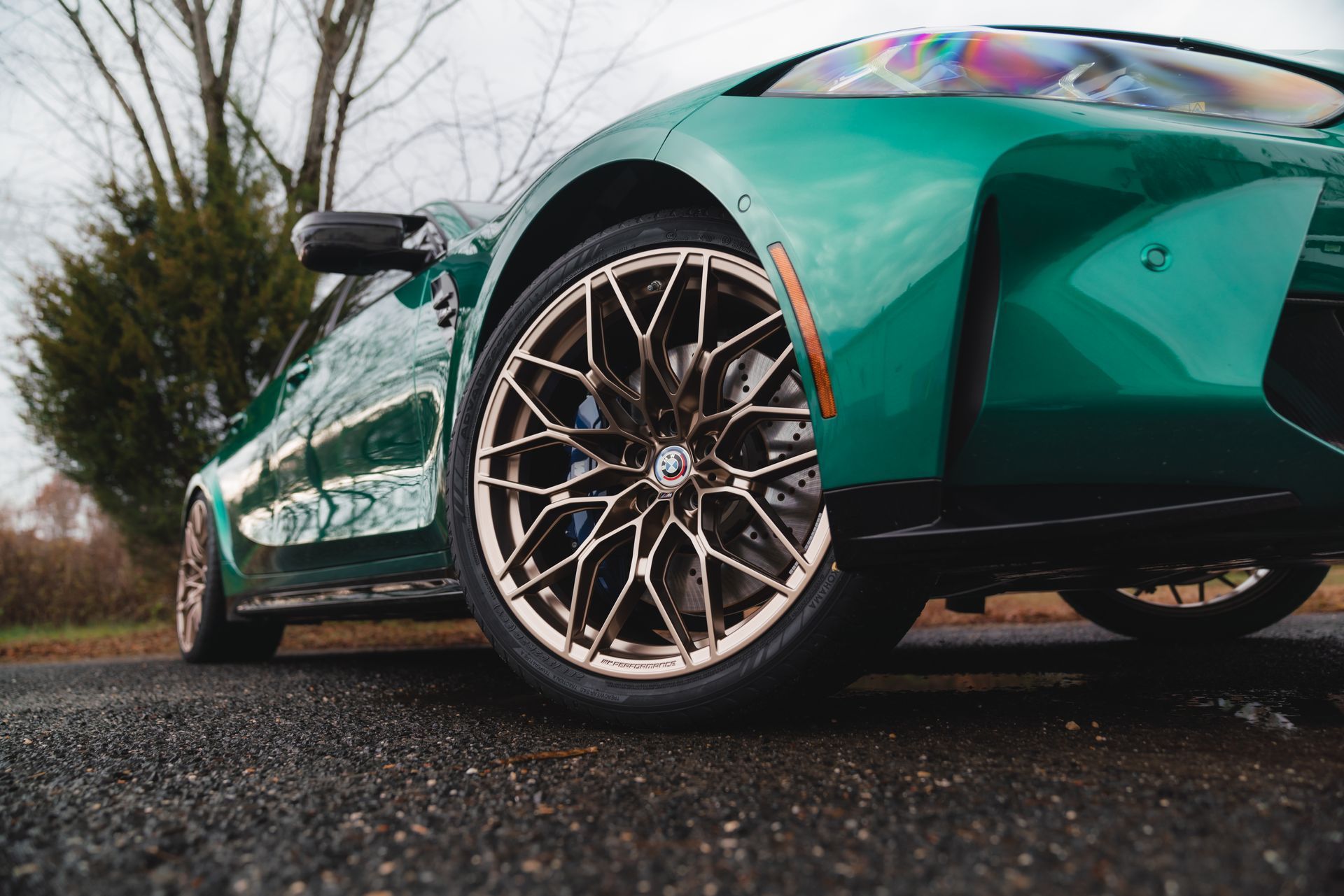 A green sports car is parked on the side of the road.