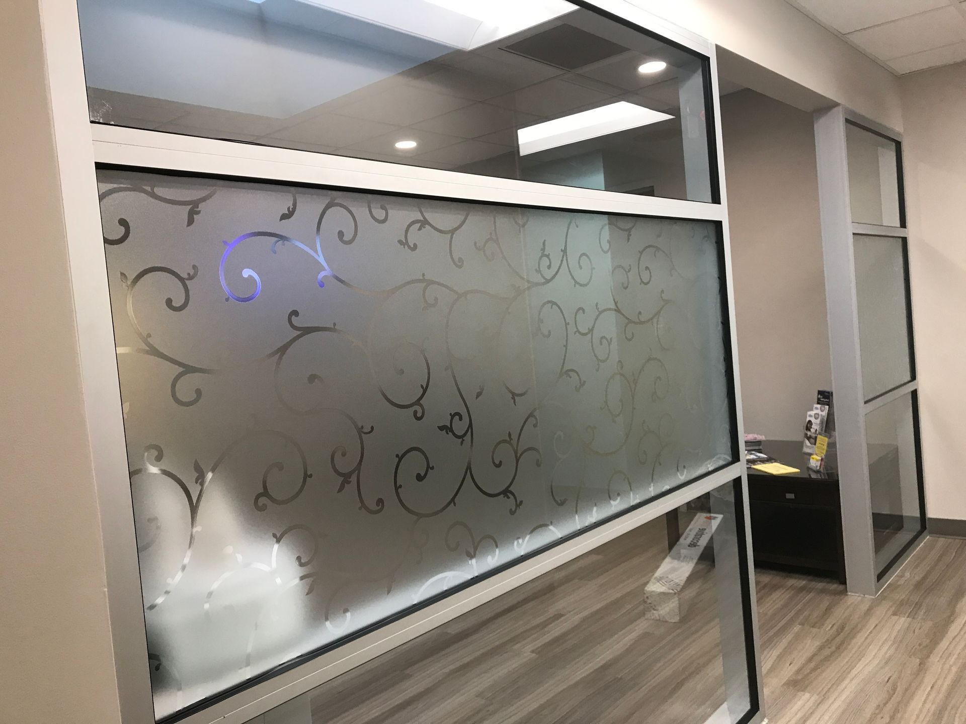 A room with a window with a swirl design on it.