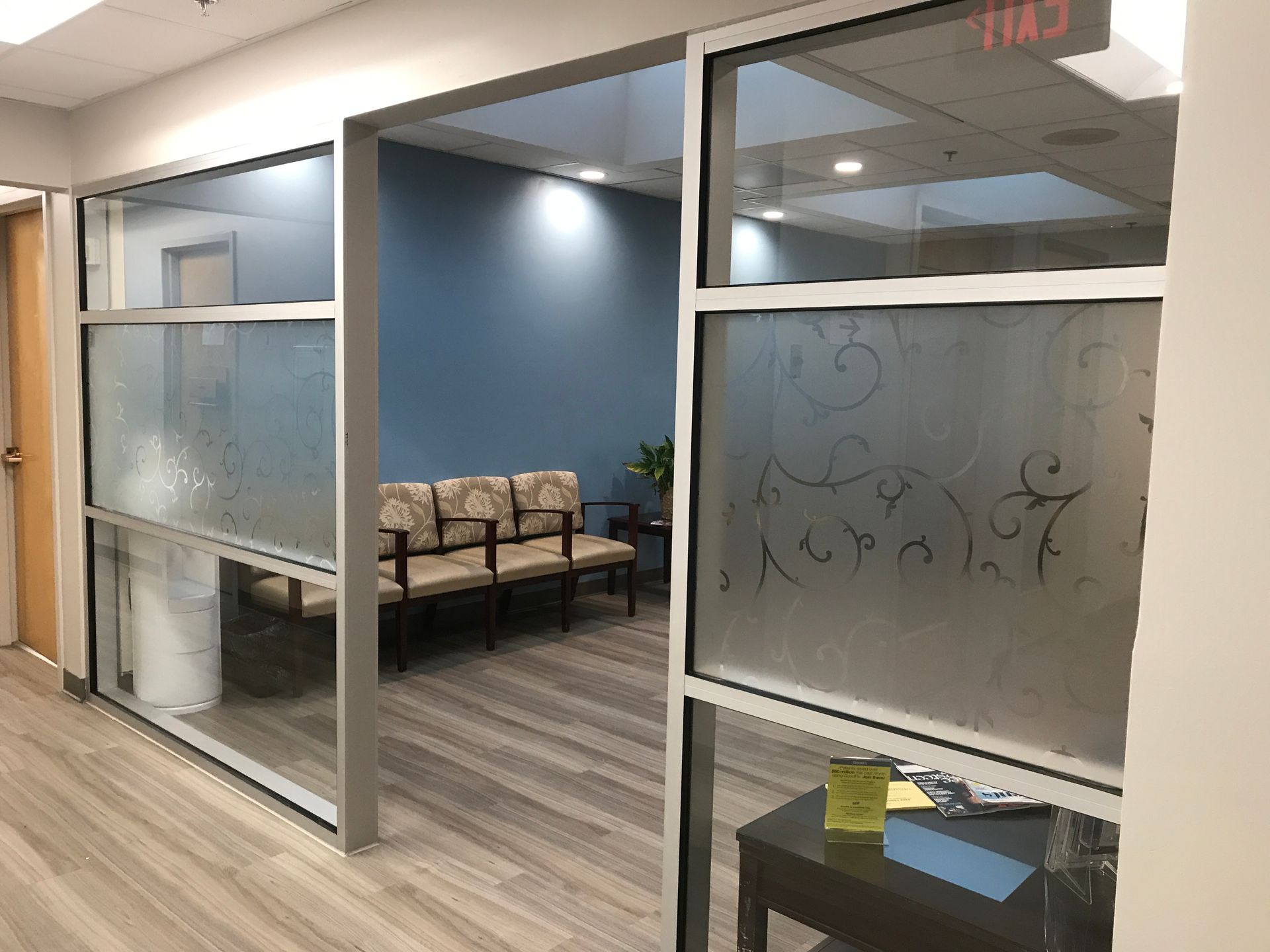 A waiting room with a row of chairs and a table.