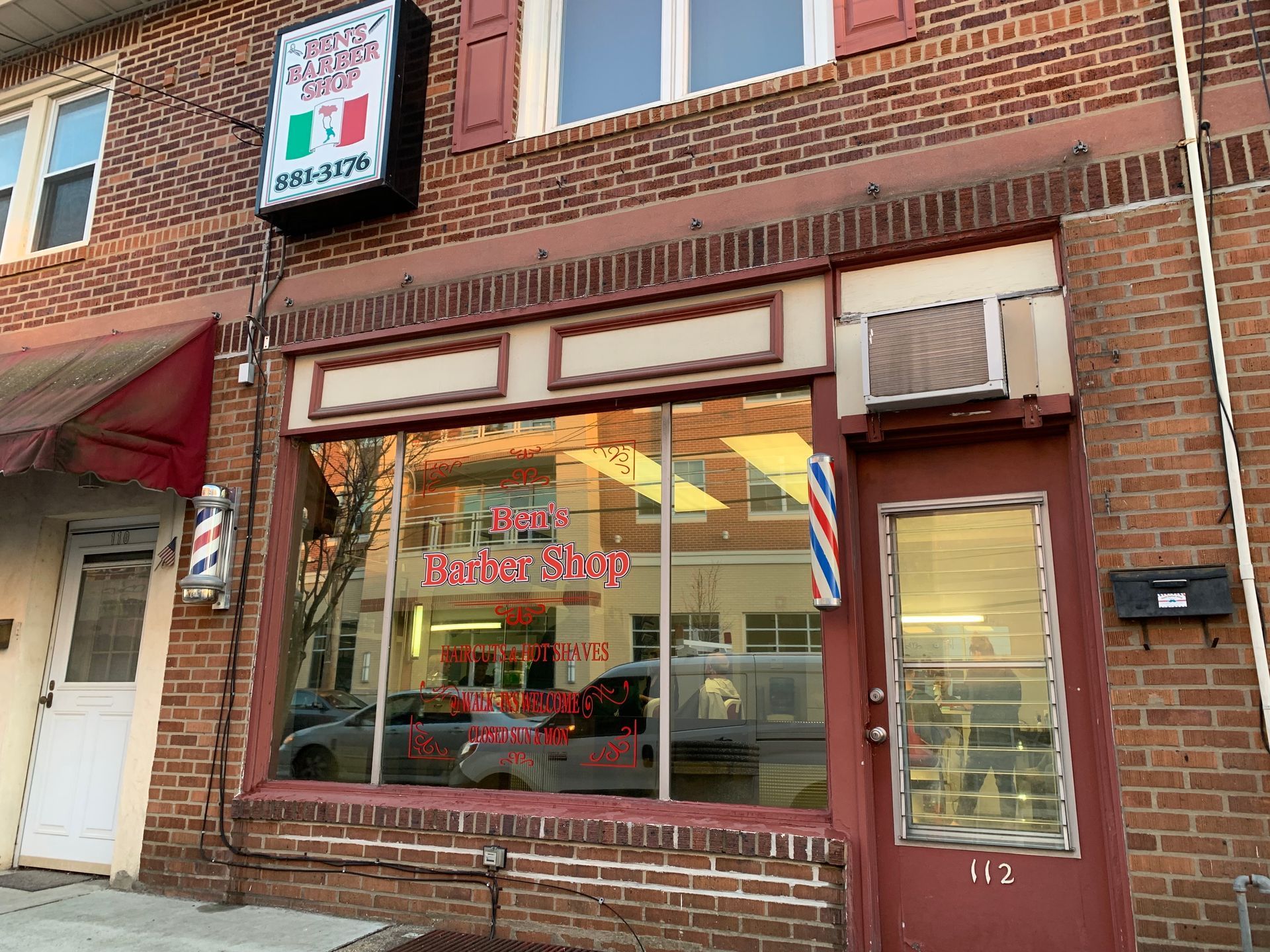 A brick building with a barber shop in front of it