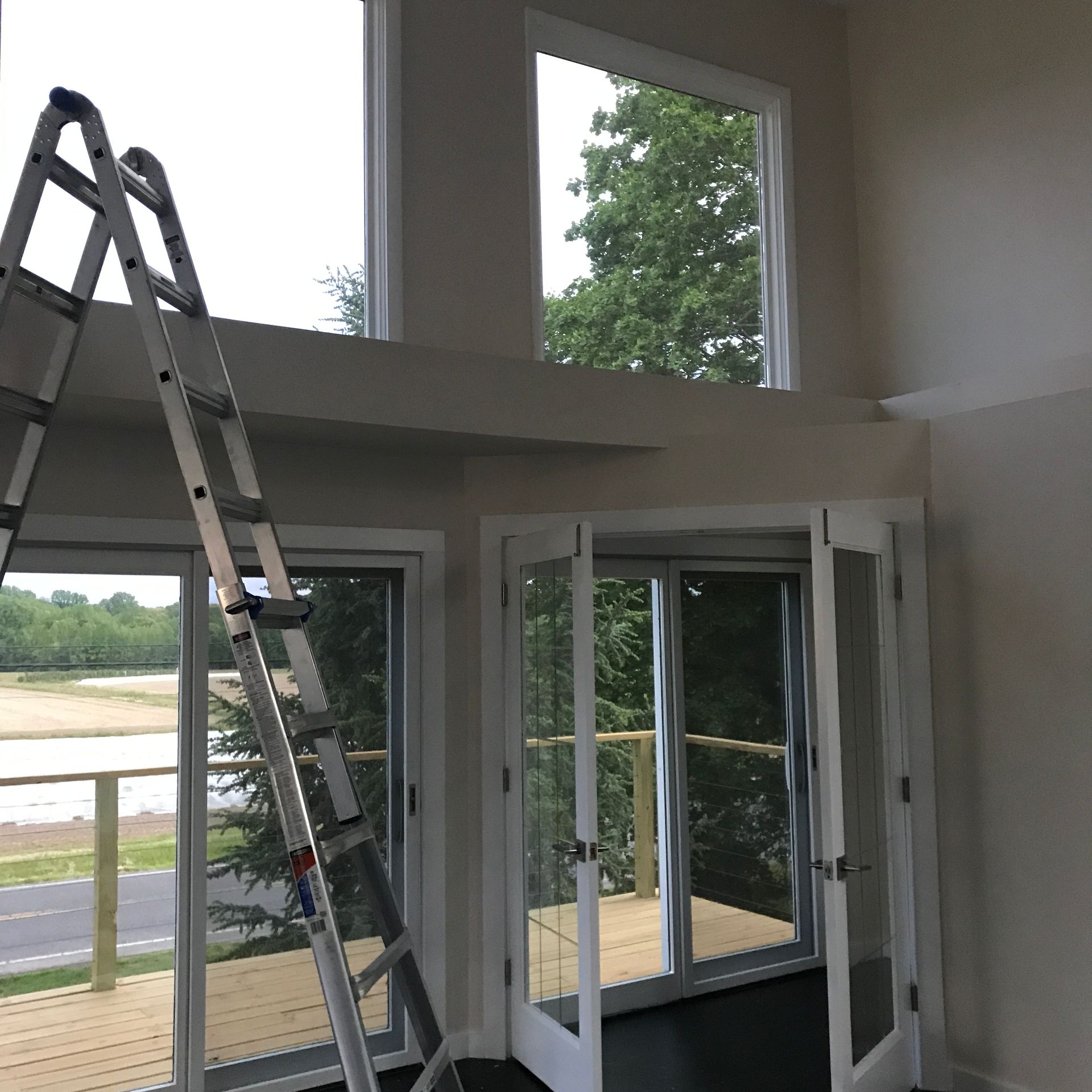 A room with a ladder and lots of windows
