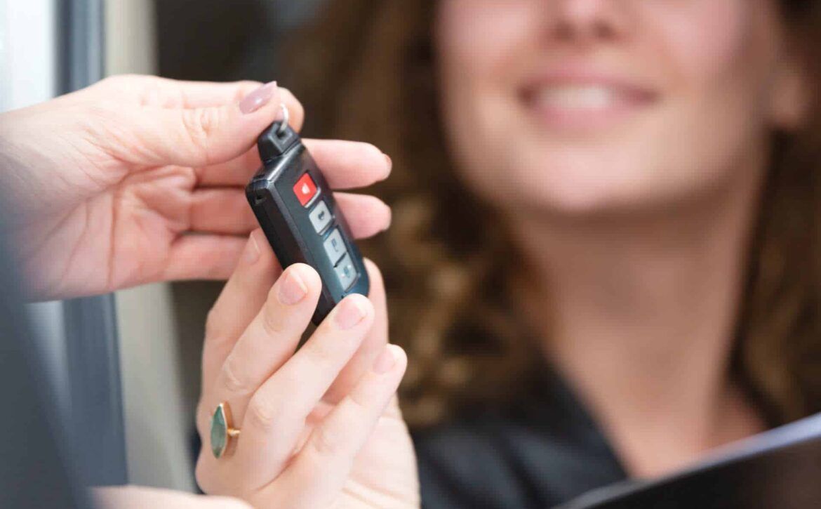 A woman is getting a car key from a man.