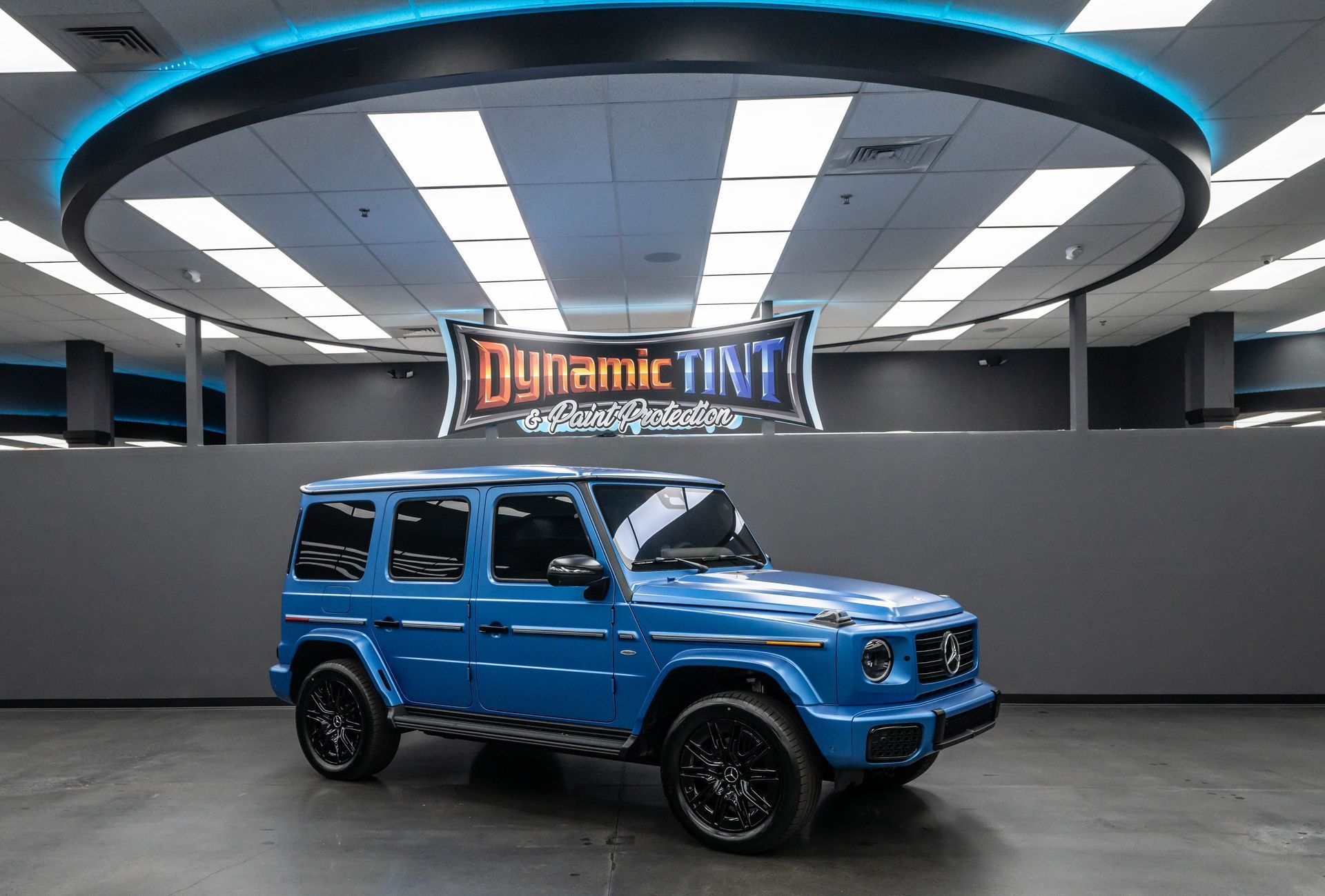 A close up of a blue car covered in plastic