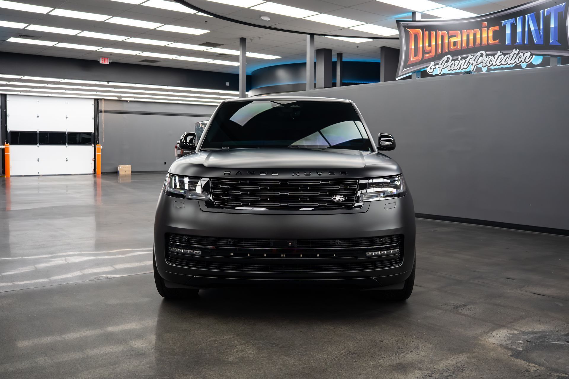 Black SUV parked indoors under bright lights.