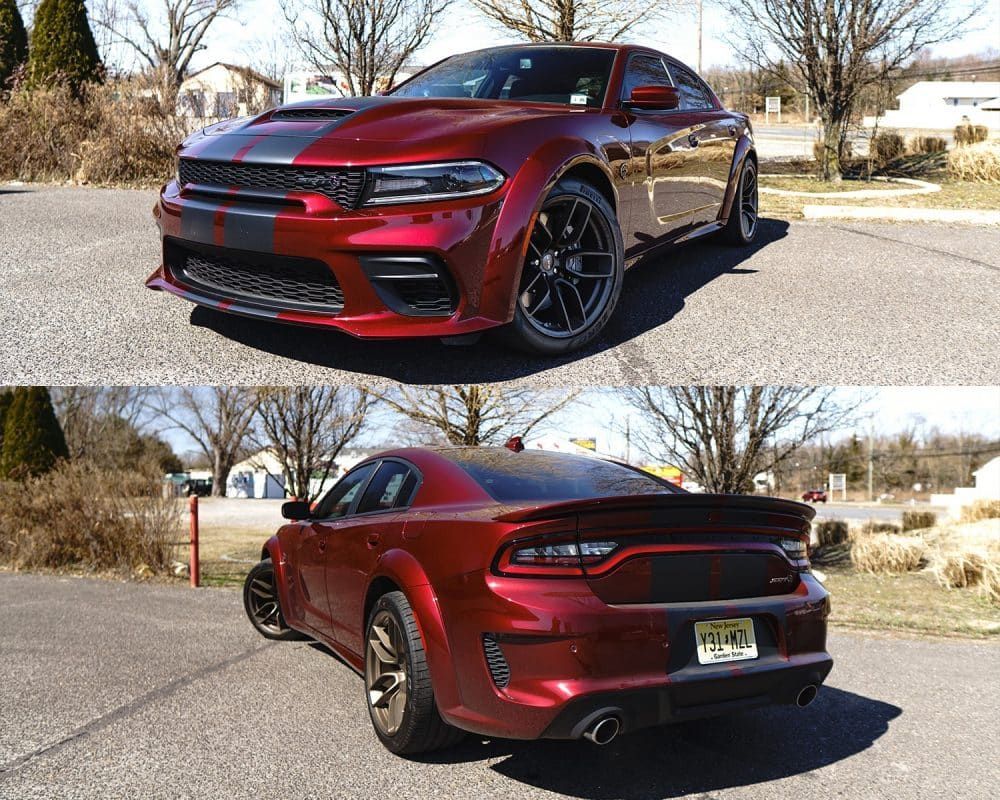 A red dodge charger is parked on the side of the road.