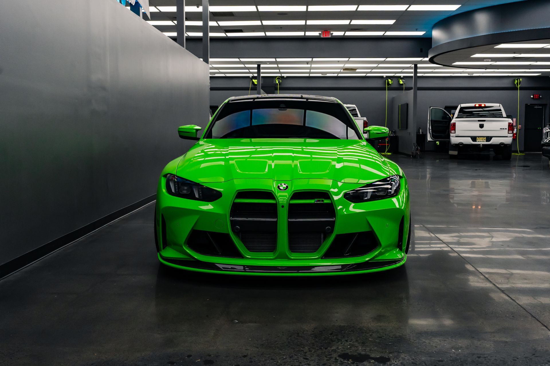 A green bmw m3 is parked in a garage.