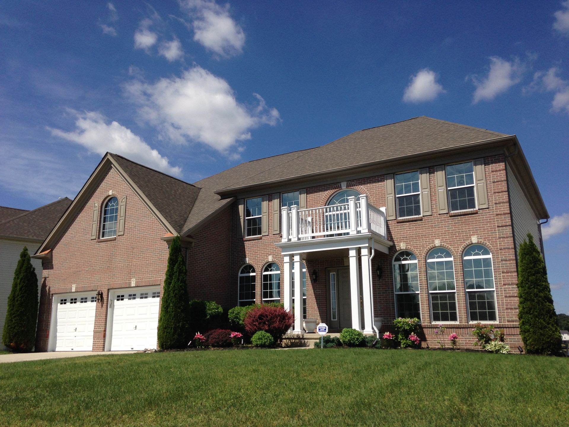 A large brick house with two garages and a porch