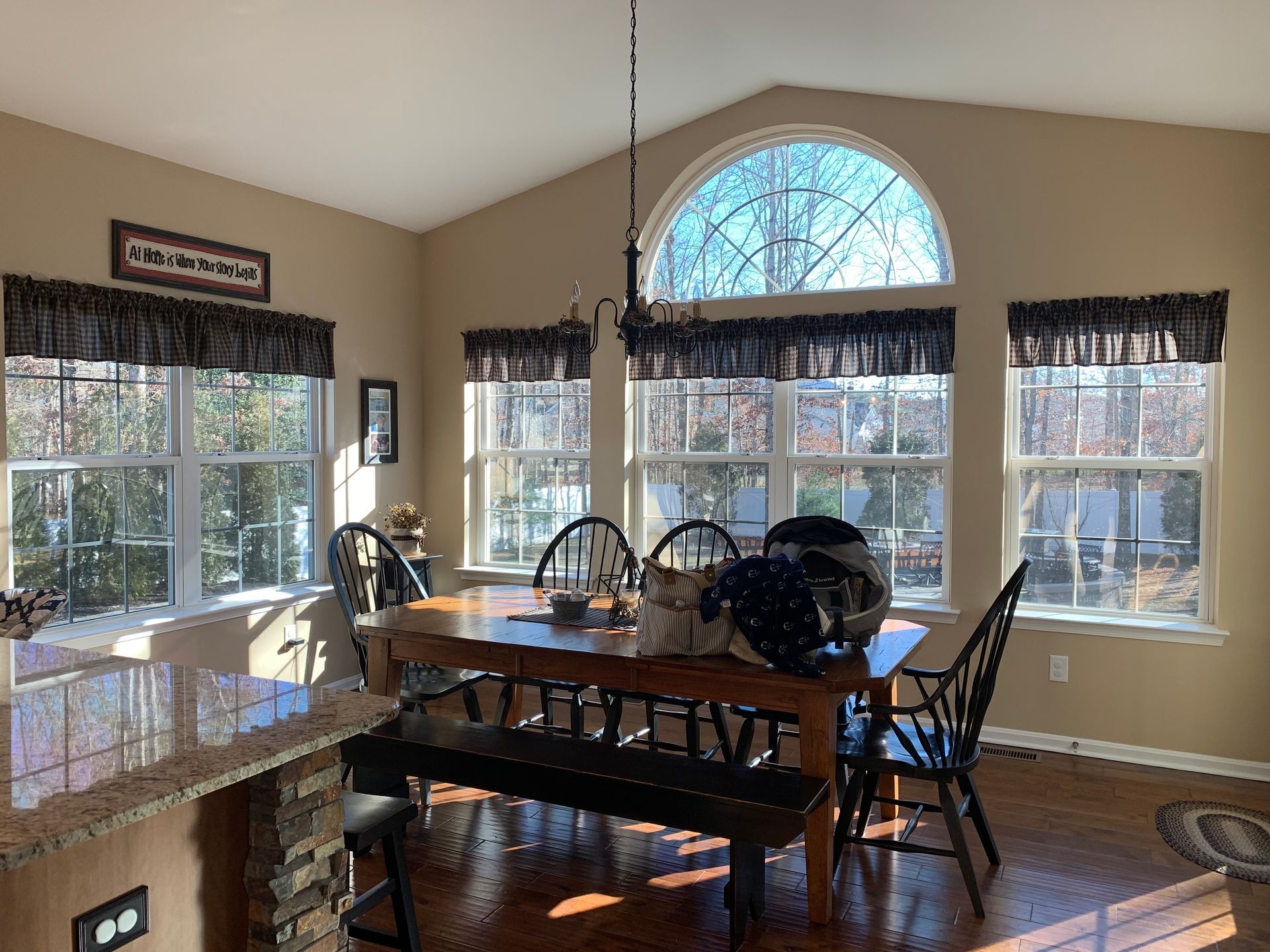 A dining room with a table and chairs and a large window.