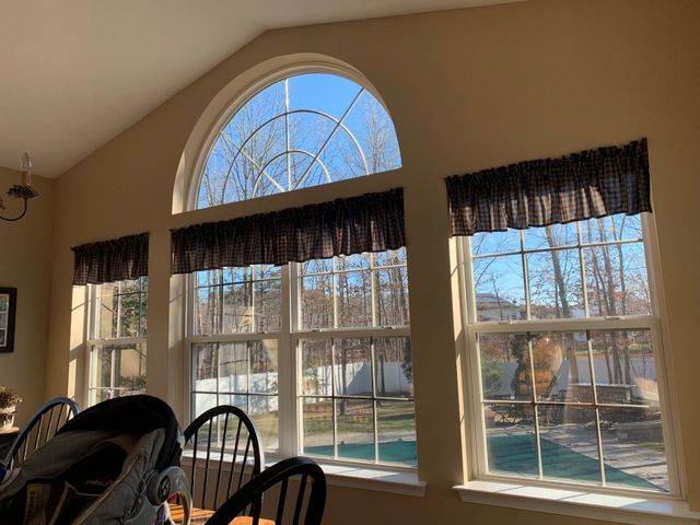 A room with a lot of windows and a table and chairs